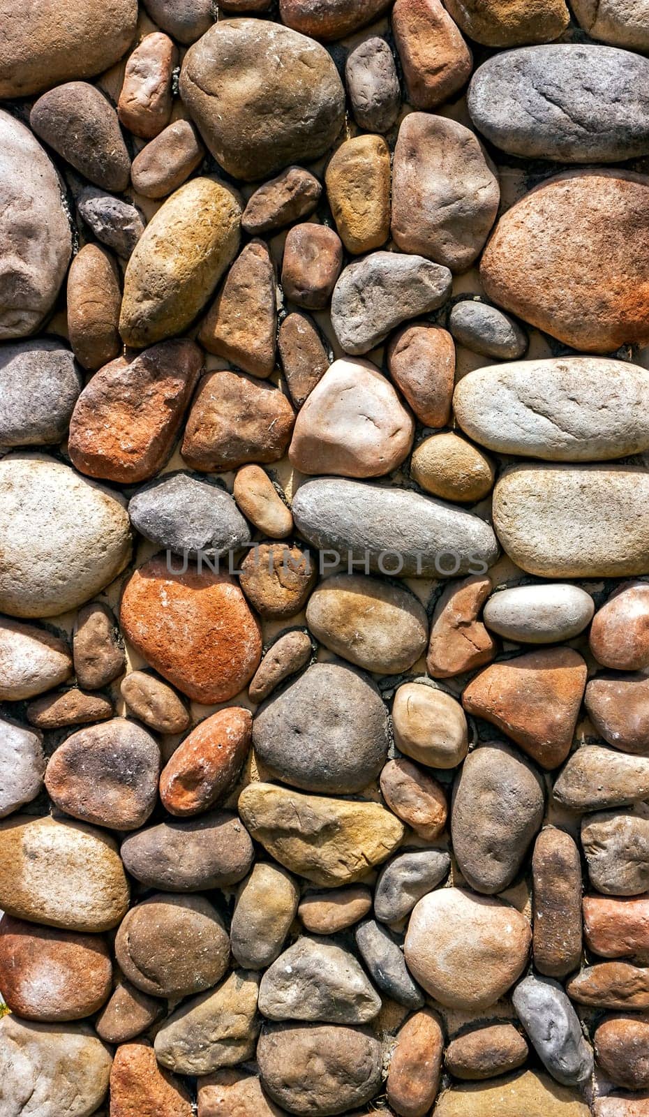 .Background of a stone wall made of cobblestones.