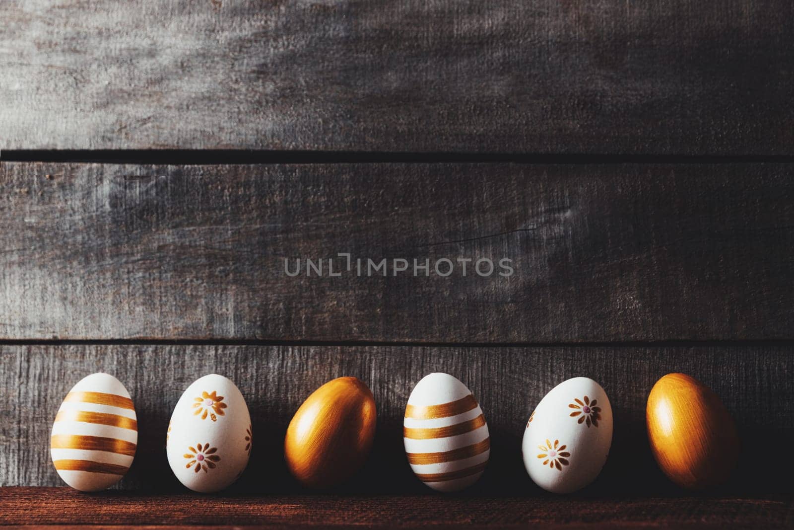 Easter holiday conceptual background on rustic wooden boards. Top view from above to different Easter eggs flat lay. Card with copy space to place text. Minimal concept. High quality photo