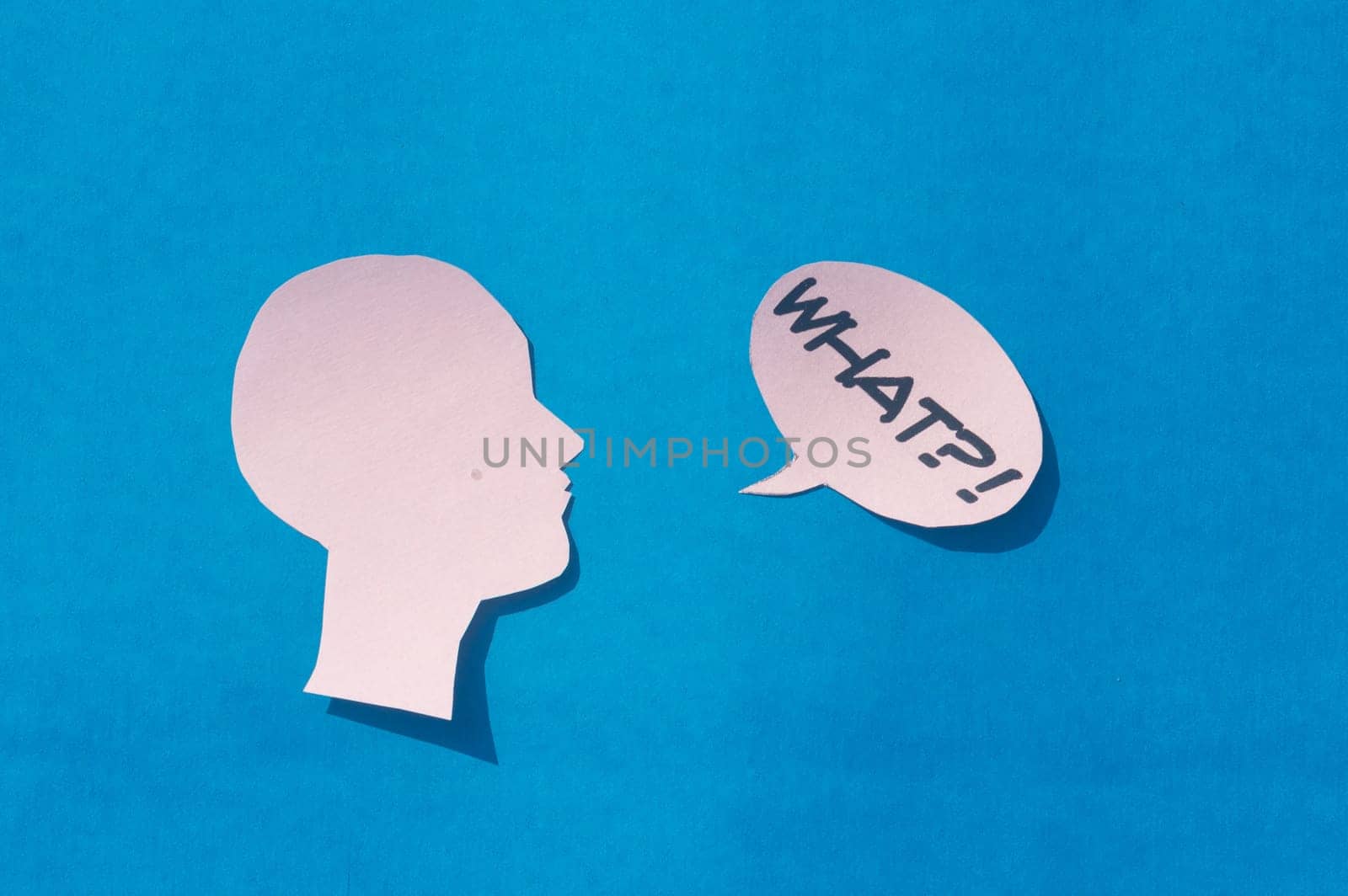 Paper Human face with What Question Mark on speech bubble isolated on blue background. Conceptual images showing to express doubt or uncertainty about something.