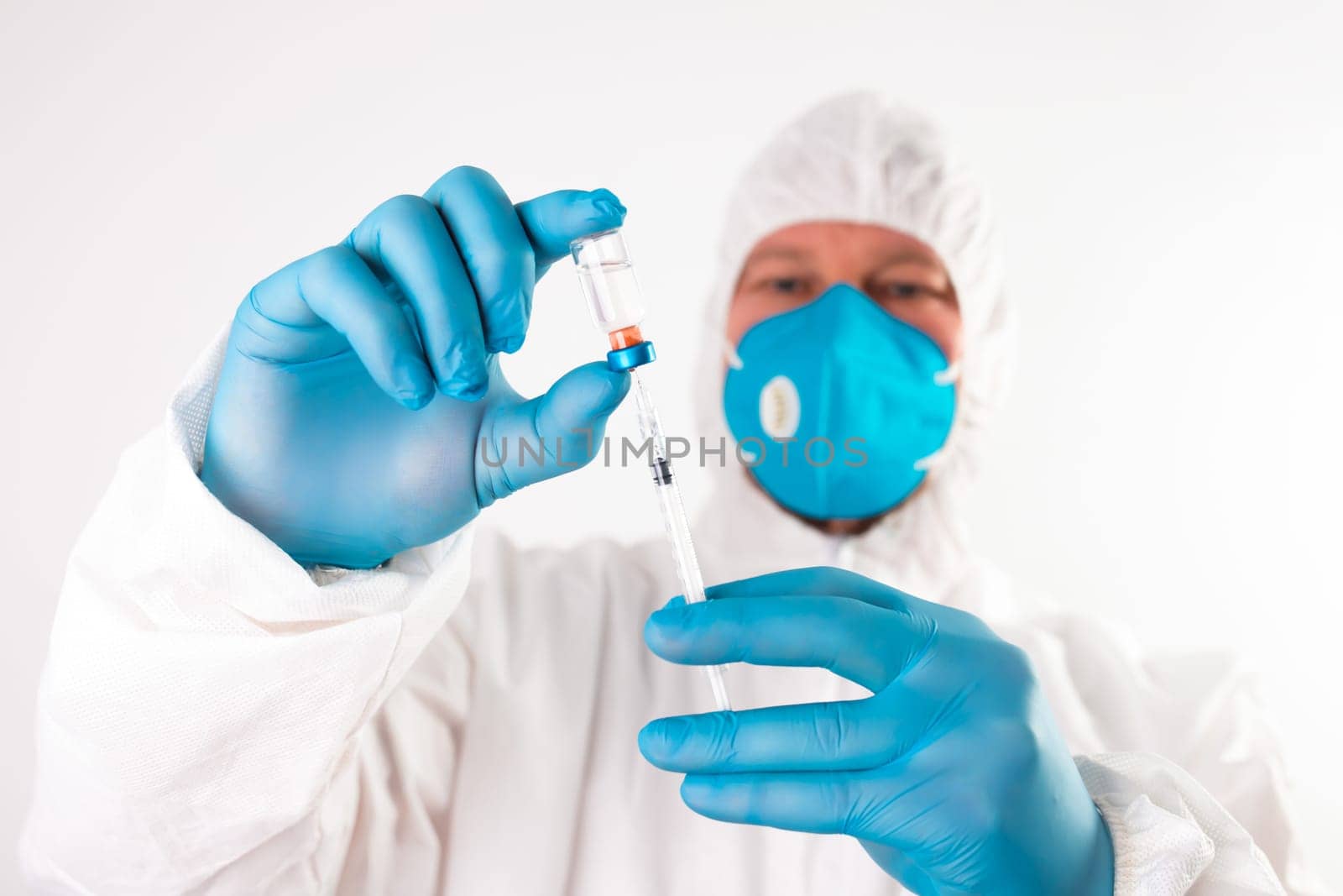 COVID-19 coronavirus vaccine. Vaccination concept. Doctor's hand in blue gloves hold medicine vaccine vial bottle and syringe.