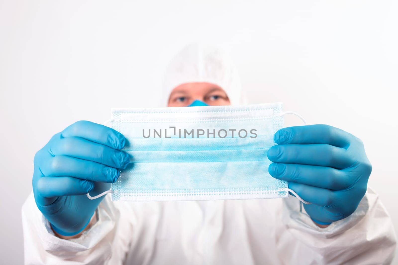 Doctor hand wear blue medical gloves holds antivirus face mask for pandemic diseases. Outbreak, Covid19 concept