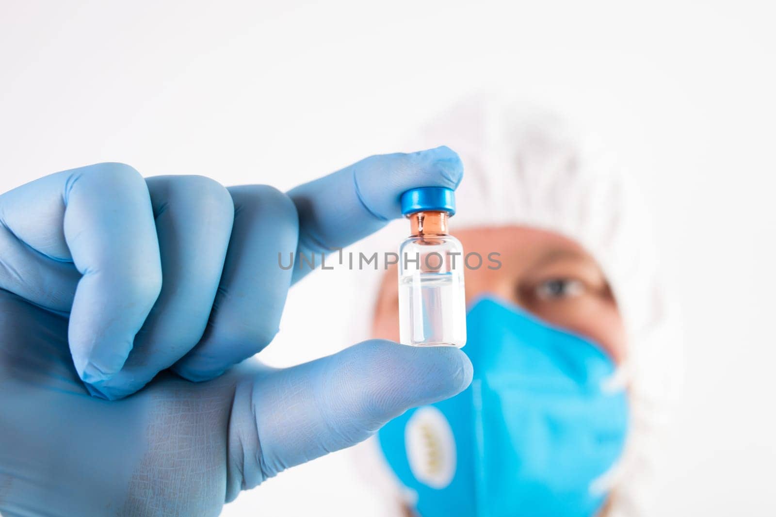 COVID-19 coronavirus vaccine. Vaccination concept. Doctor's hand in blue gloves hold medicine vaccine vial bottle and syringe.