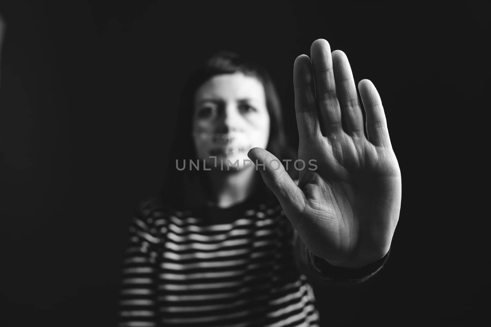 Women violence and abused concept. Stop domestic violence against women and human trafficking.Woman with tape on mouth and stop violence text
