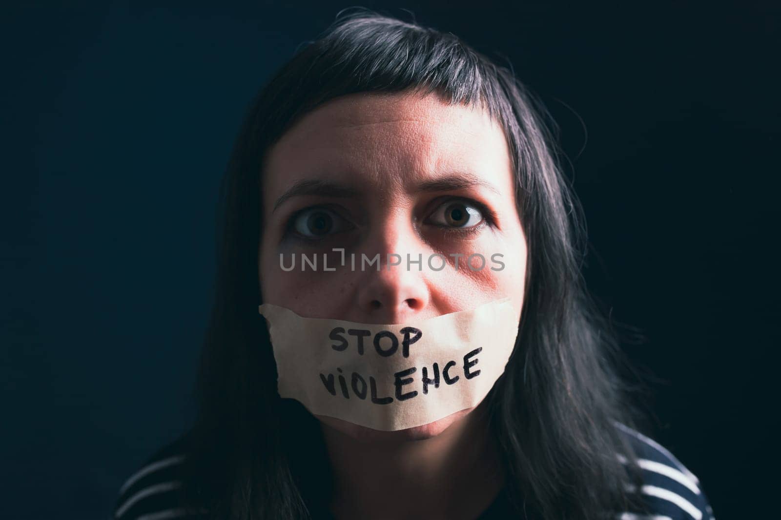 Women violence and abused concept. Stop domestic violence against women and human trafficking.Woman with tape on mouth and stop violence text