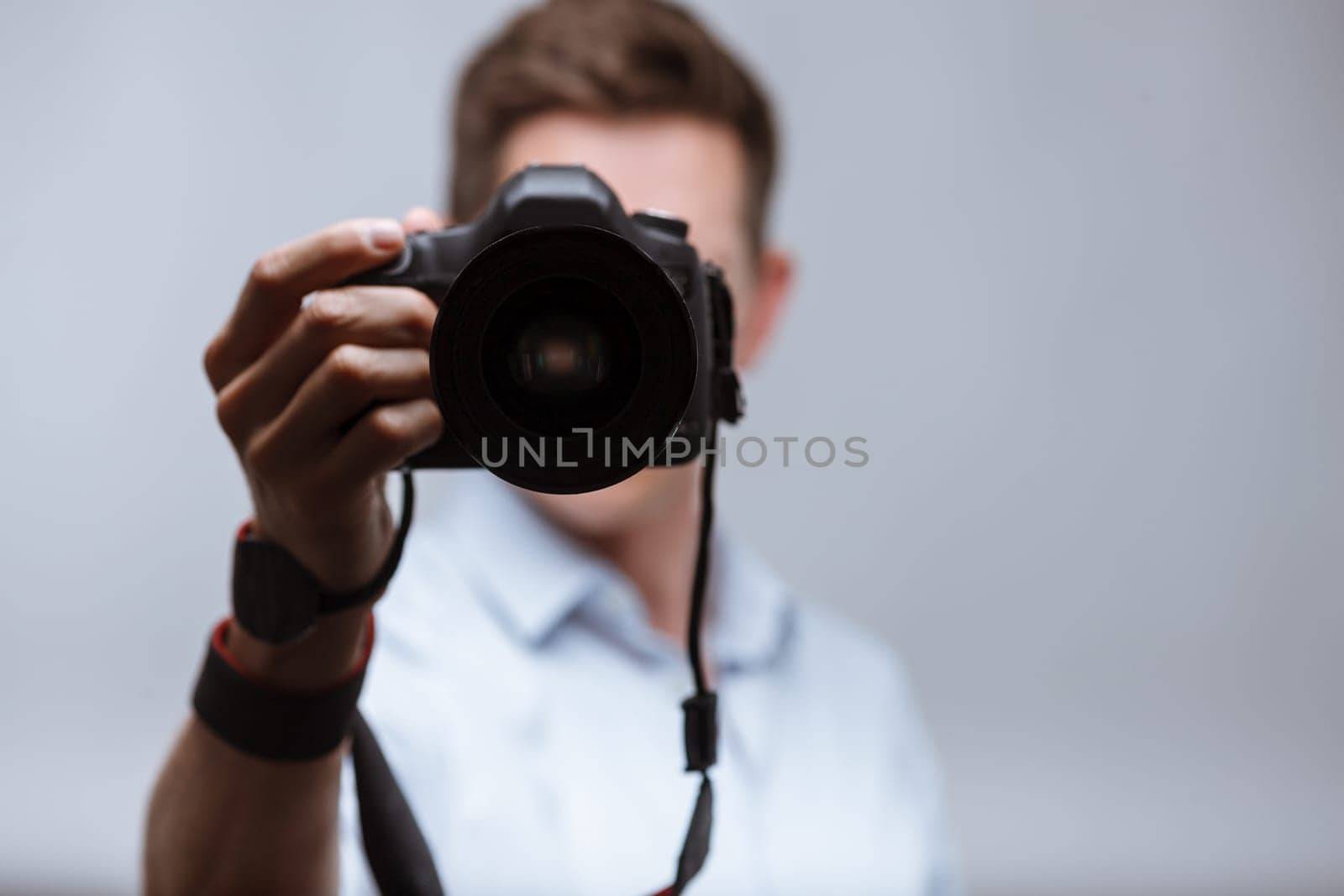 Photographer holding dslr camera on bright backround
