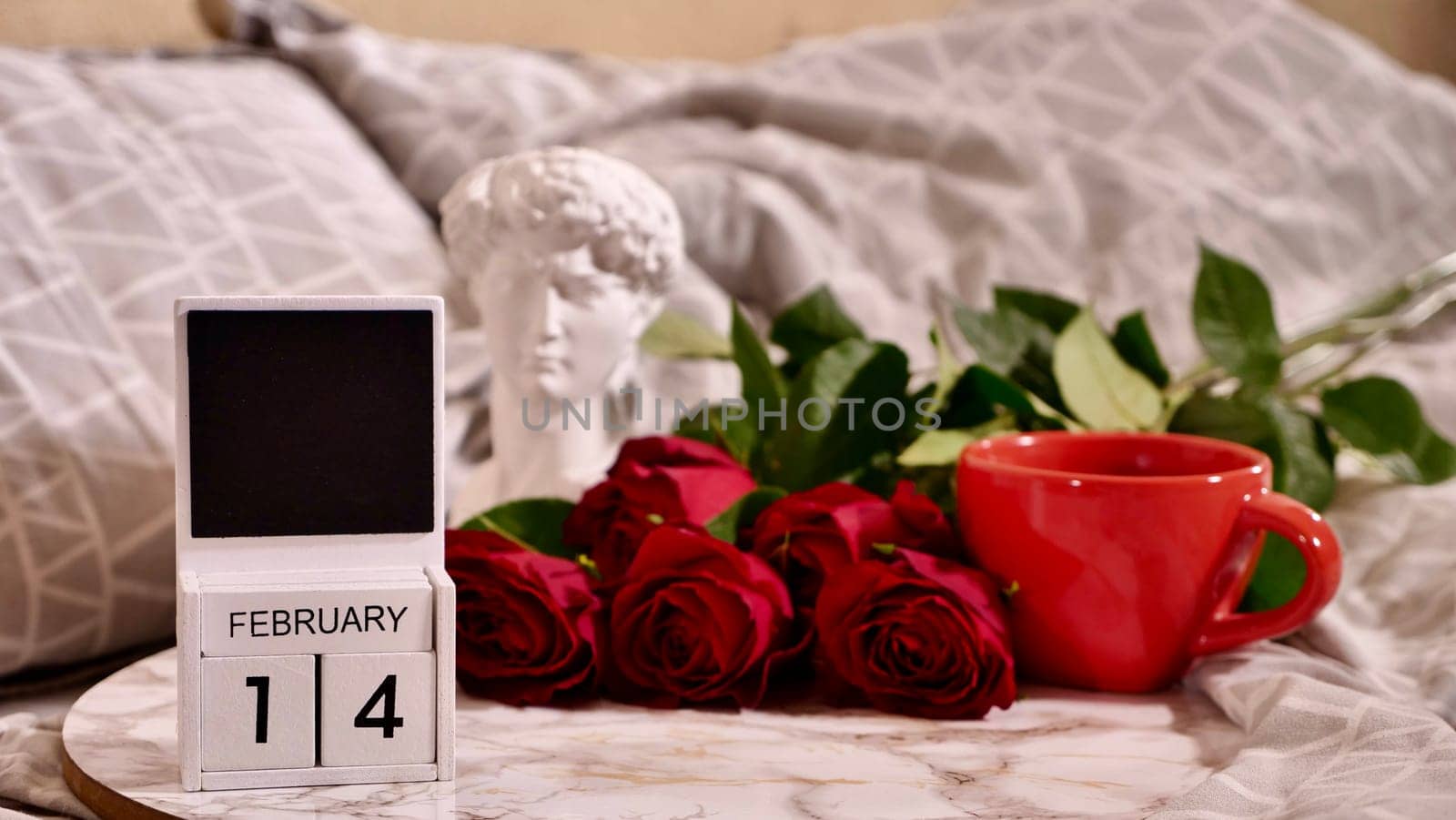 Festive Flatlay, composition for Valentine's Day on February 14. Coffee in a red cup and red rose flowers at home in bed
