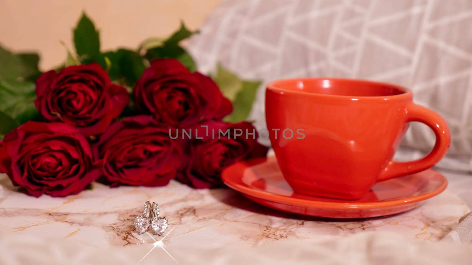 Background Festive Flatlay, composition for Valentine's Day on February 14. Coffee in a red cup, red rose flowers and diamond heart earrings