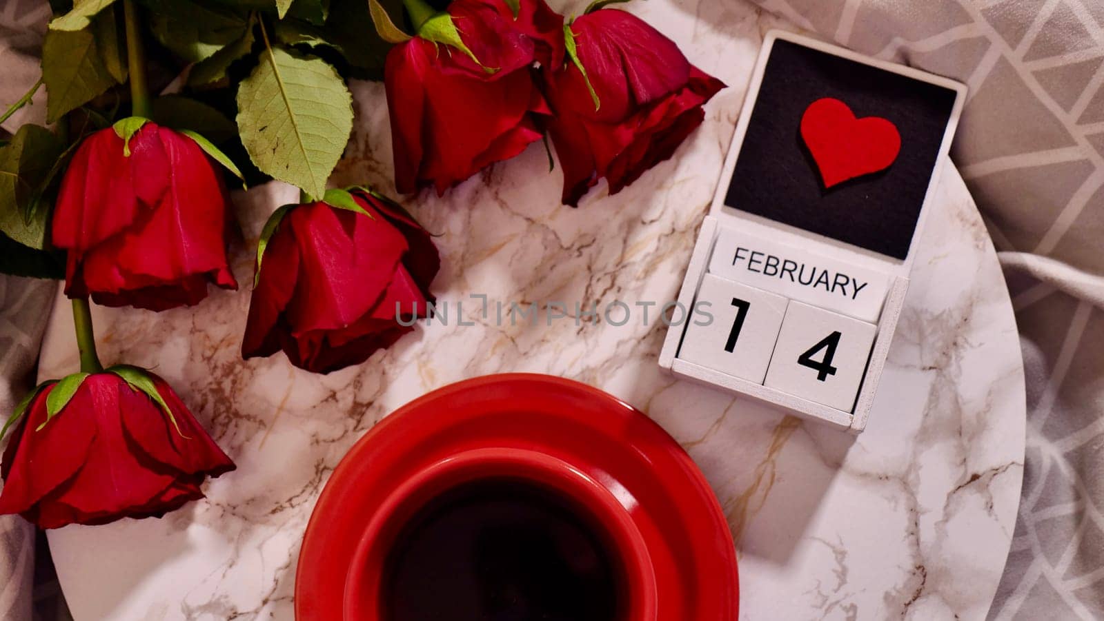 Festive Flatlay, composition for Valentine's Day on February 14. Coffee in a red cup and red rose flowers at home in bed