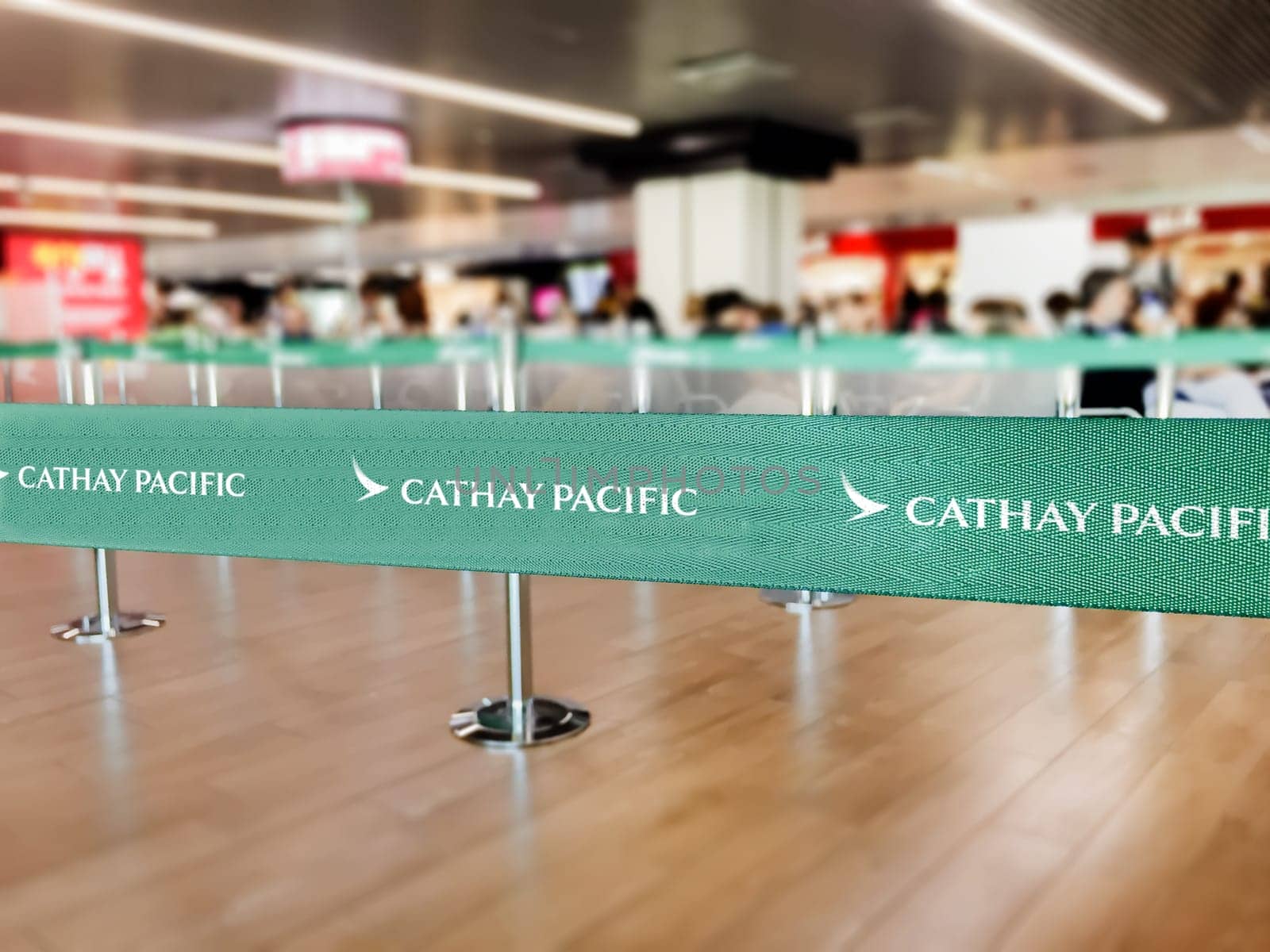 Hong Kong, CHN, July 2019: Green belt barrier with white Cathay Pacific airlines logo. Cathay Pacific is the flag carrier airline of Hong Kong. Travel and airport security