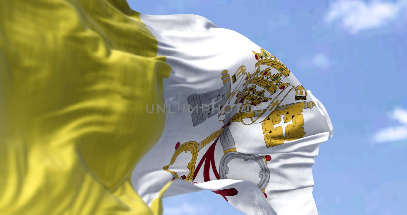 Detail of the national flag of Vatican state waving in the wind on a clear day. Religion and politics. Selective focus. City state in Rome, Italy