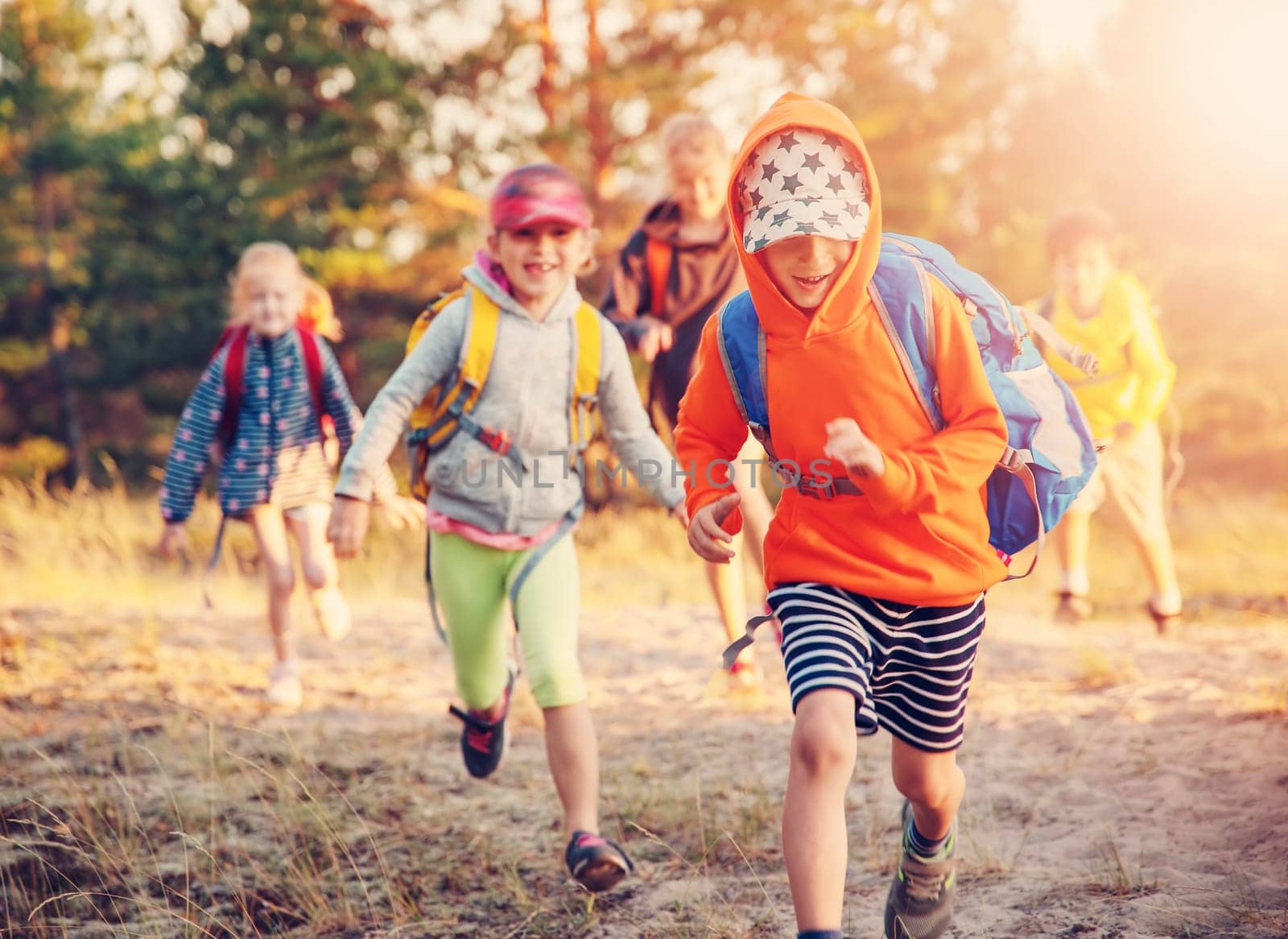 Group of the children with backpacks on the nature near the sea. Concept of the hiking and children's scout camping.