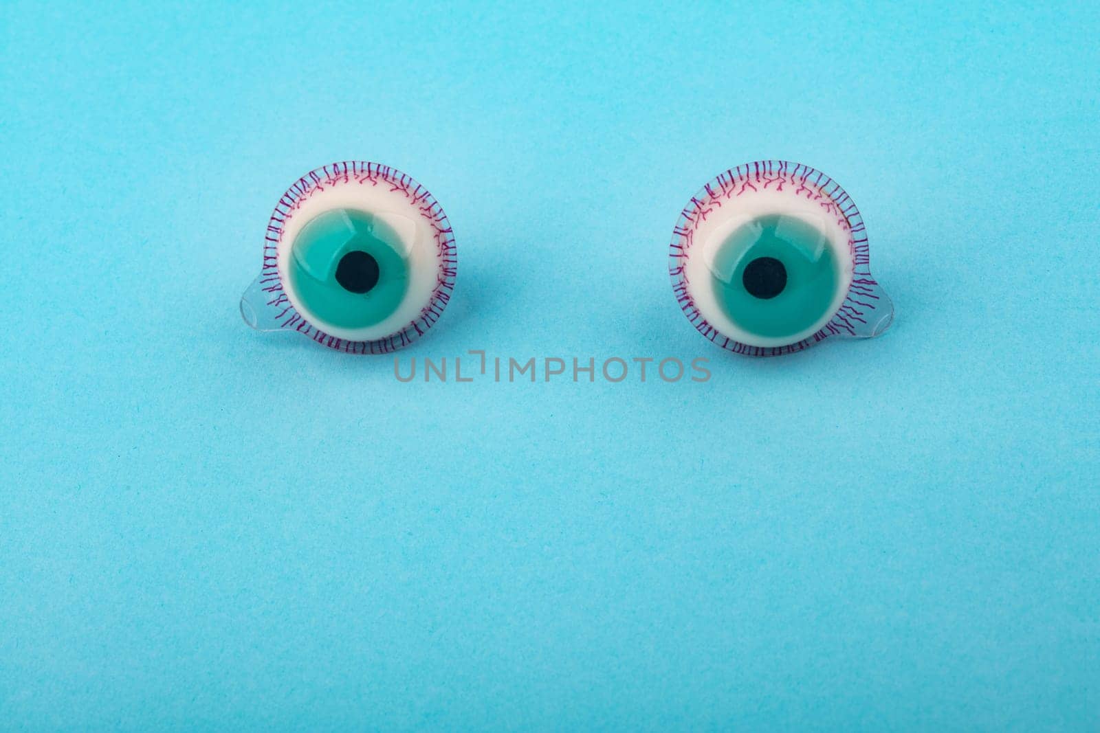 Decorative fruit candy eyes over light blue background. Conceptual photo using for funny celebration themes.