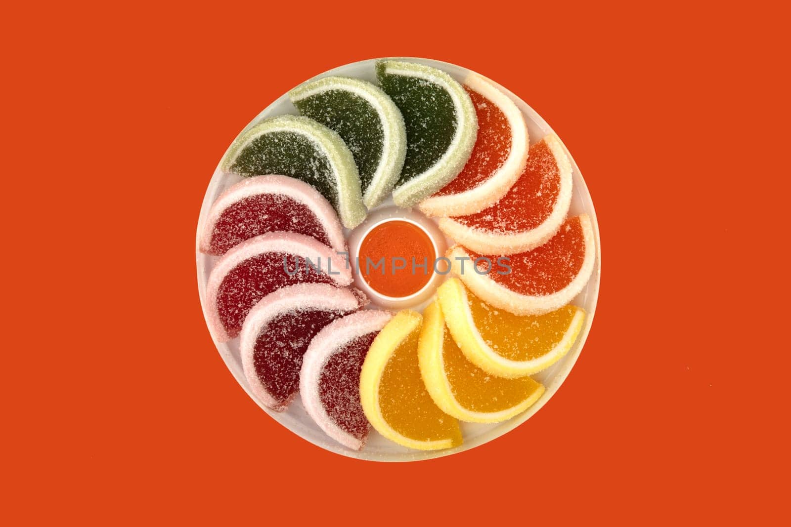 Colorful slices from fruit jelly candy isolated on orange background