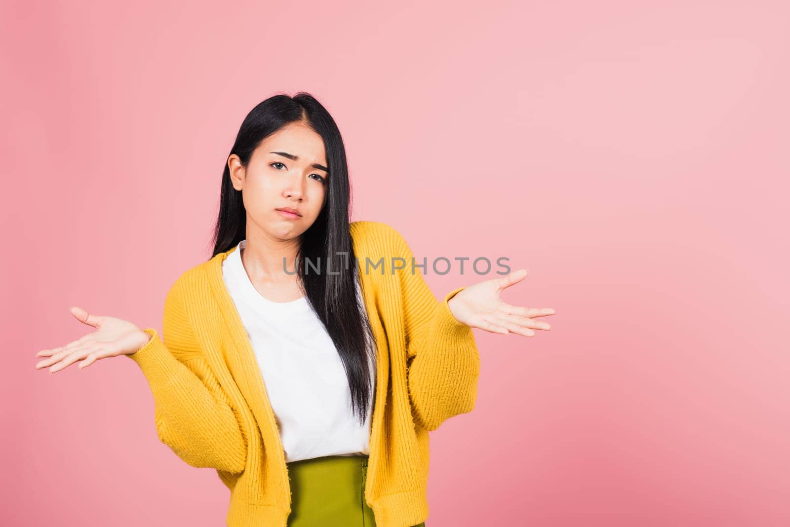 Asian portrait beautiful cute young woman teen shrugging with spread hands she shocked dont understand and confused studio shot isolated on pink background, female doubt with copy space