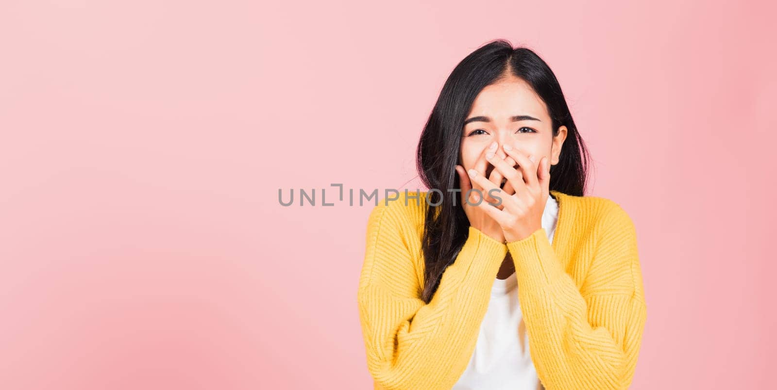 Asian portrait beautiful cute young woman standing amazed, shocked afraid mouth covered gesturing hand palms looking camera, studio shot isolated on pink background, Thai female scared with copy space