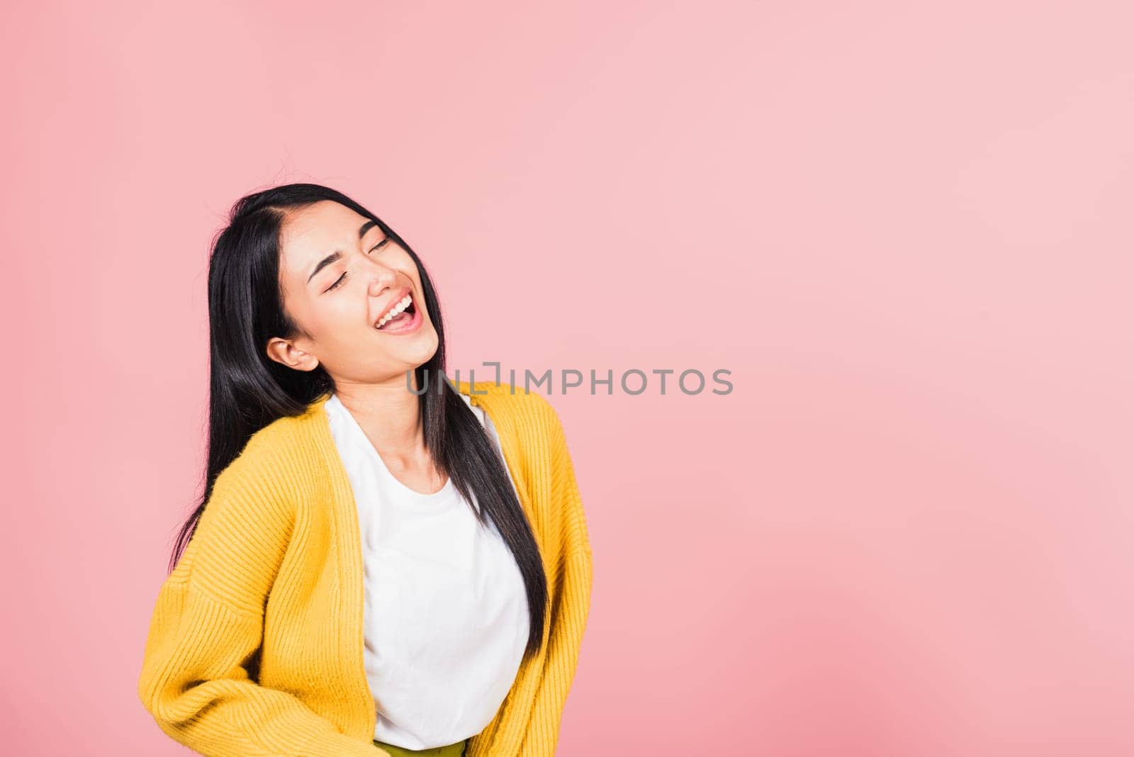 Happy Asian portrait beautiful cute young woman standing winning and surprised excited screaming laughing look face up, studio shot isolated pink background, Thai female smiley funny with copy space