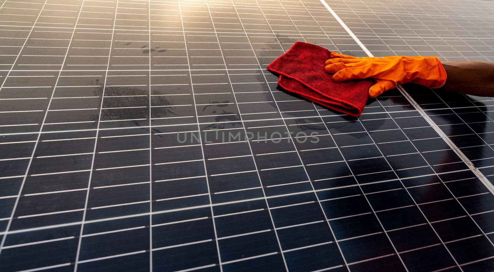 Cleaner cleaning solar panel on roof. Solar panel or photovoltaic module maintenance. Sustainable resource and renewable energy for go green. Solar power for green energy. Technology for future.
