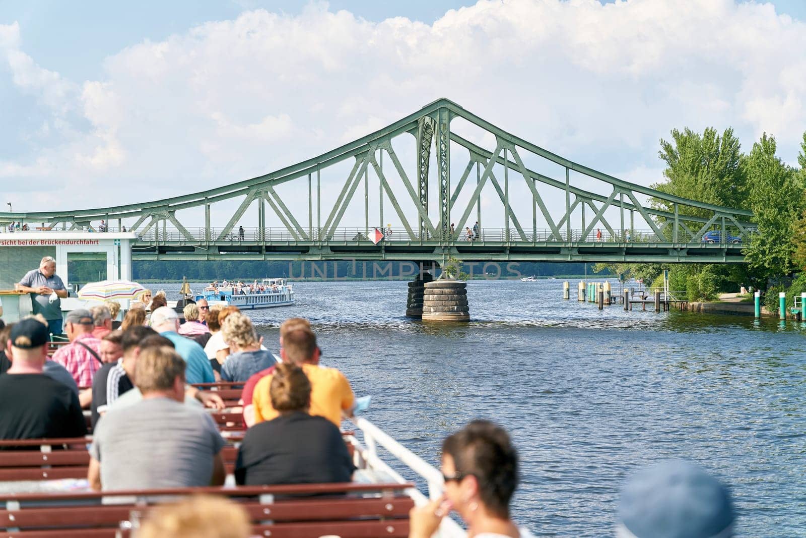 Excursion boat on the Havel River at Glienicke Bridge between Berlin and Potsdam. The bridge was used during the Cold War for the exchange of agents between Eastern Europe and Western Europe.
