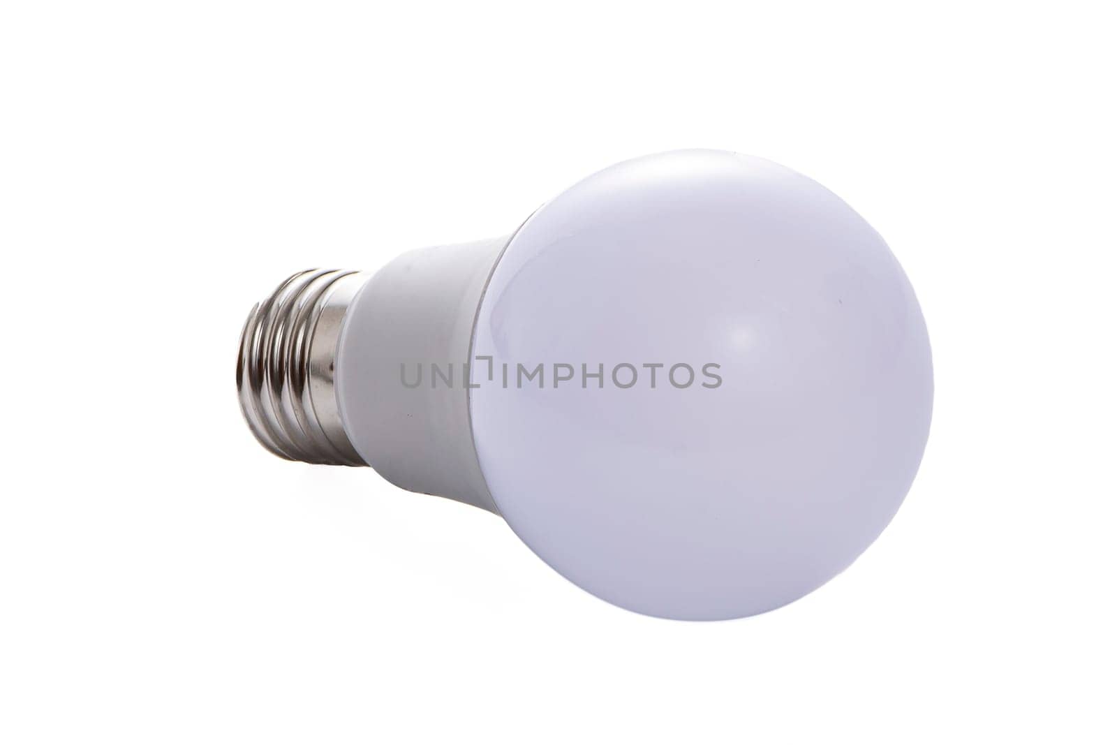 A white LED lamp with an E27 base lies on a white insulated background. High quality photo