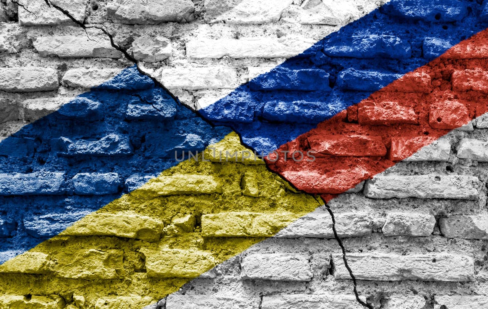 the flags of Ukraine and Russia painted on a ruined bricked wall and divided by a diagonal crack. International diplomatic relations.