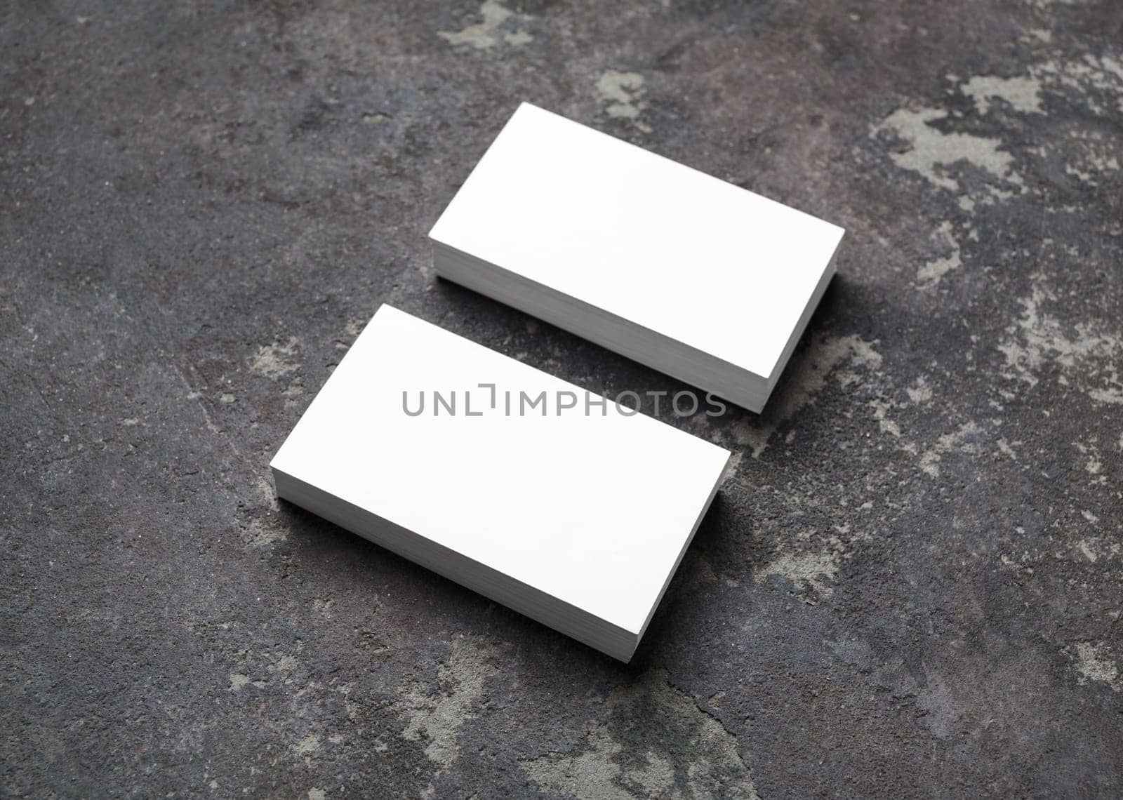 Blank white business cards on concrete background. Mockup for branding identity.