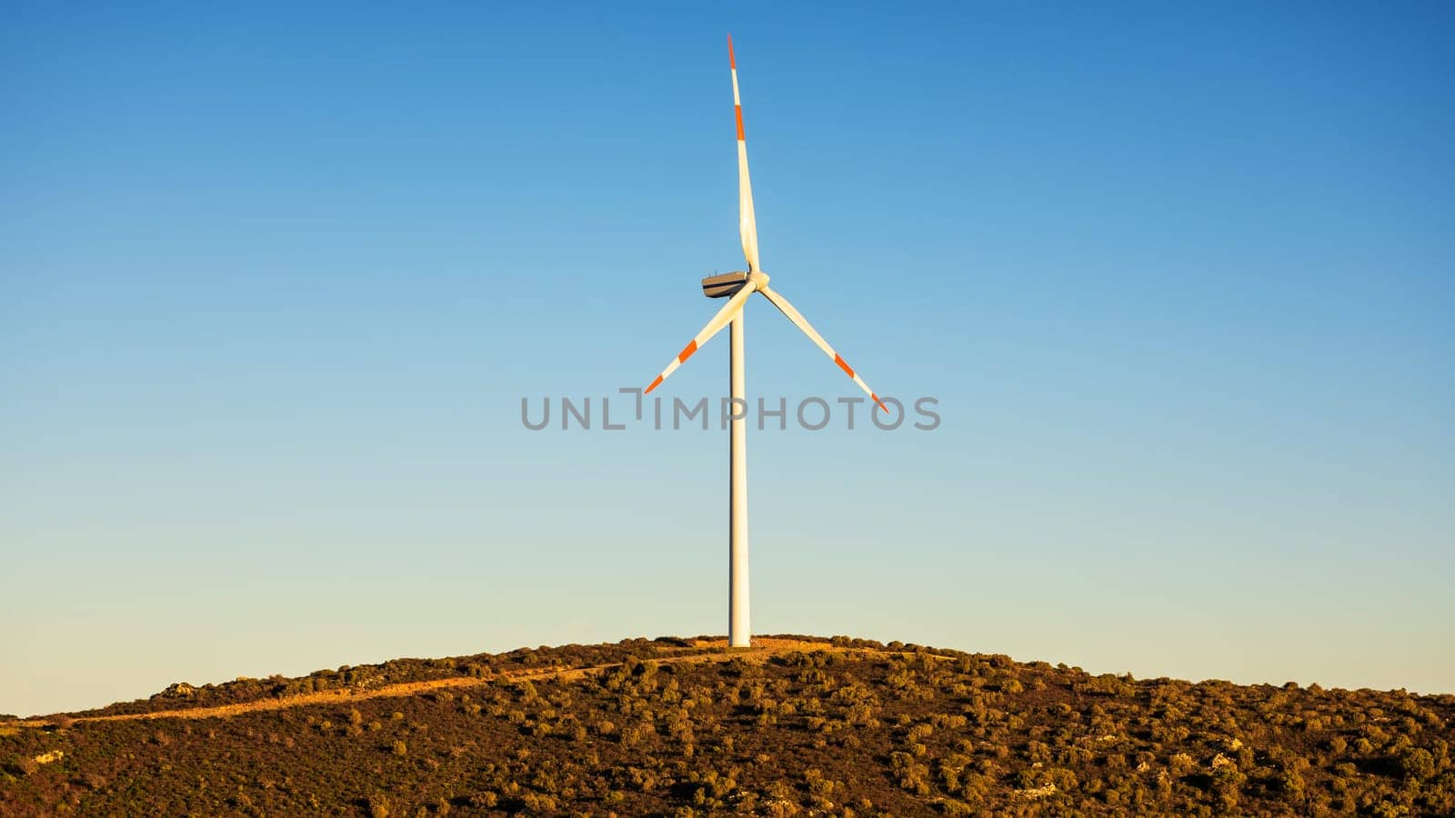 Wind turbines on a beautiful sunset sky in a mountain wind farm in Sardinia. Renewable energy concept, green energy generation. Energy industry.