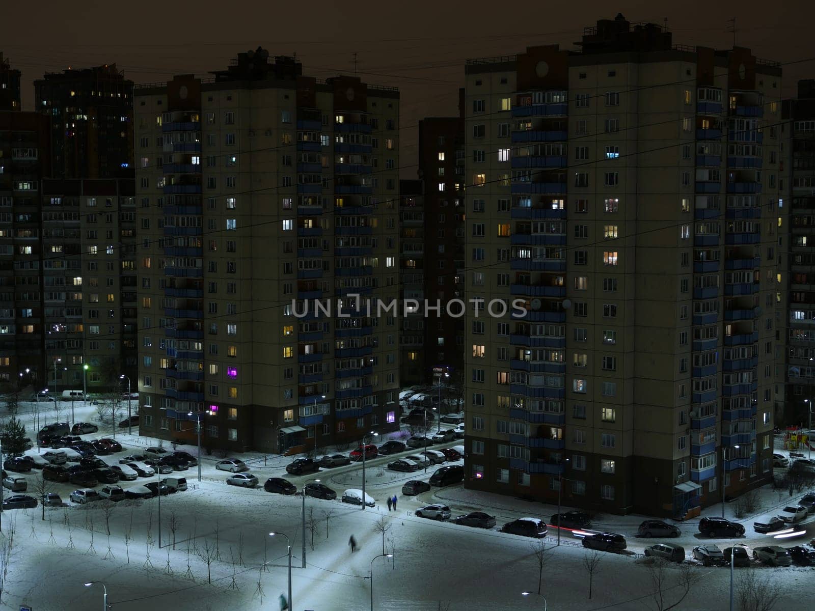 St. Petersburg snow-covered city at night in winter, lights are on in the windows, lonely passers-by rush home