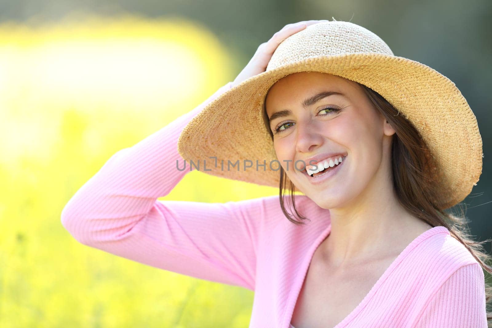 Beautiful woman with pamela looks at you in a field