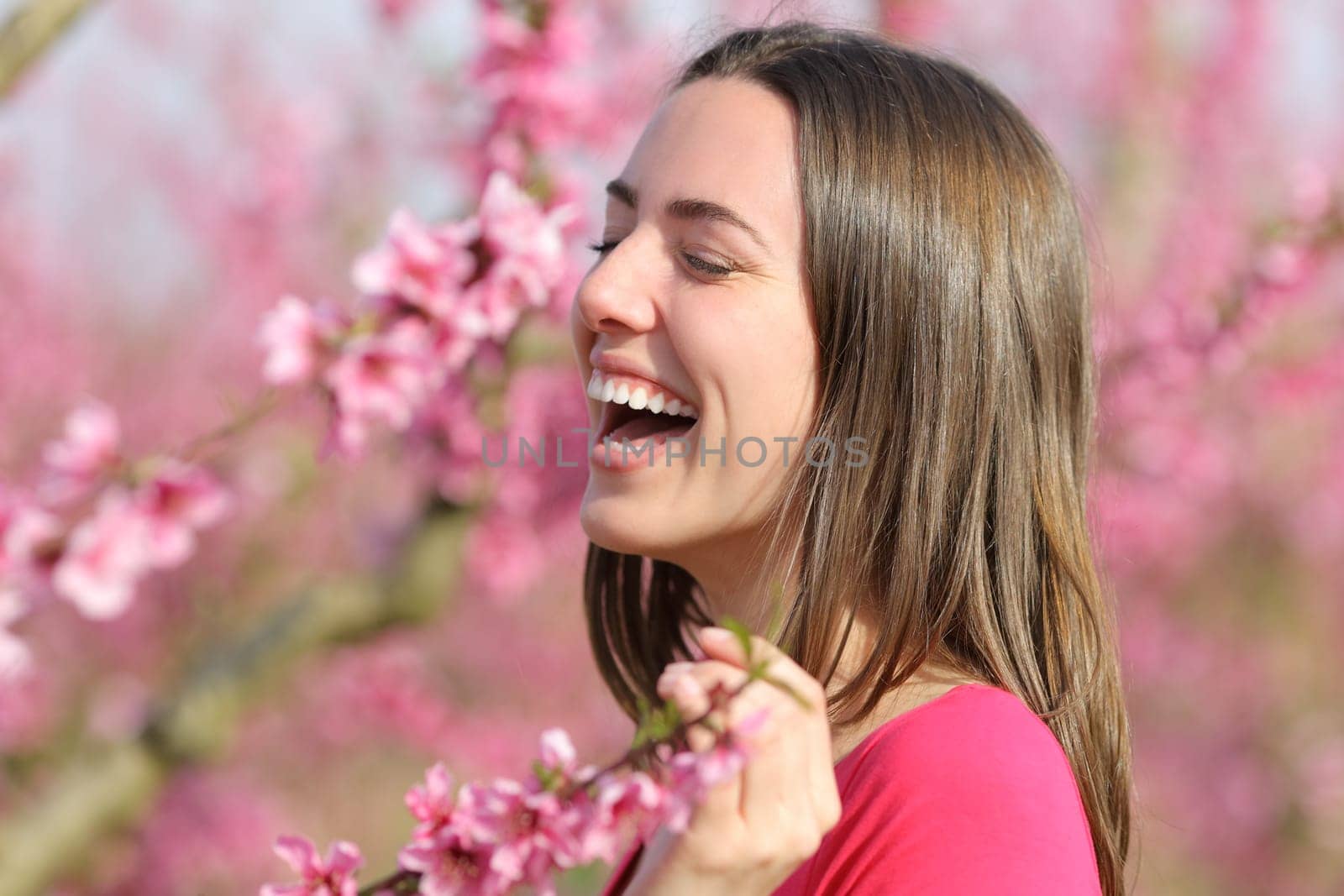 Happy and beautiful woman laughing in a field