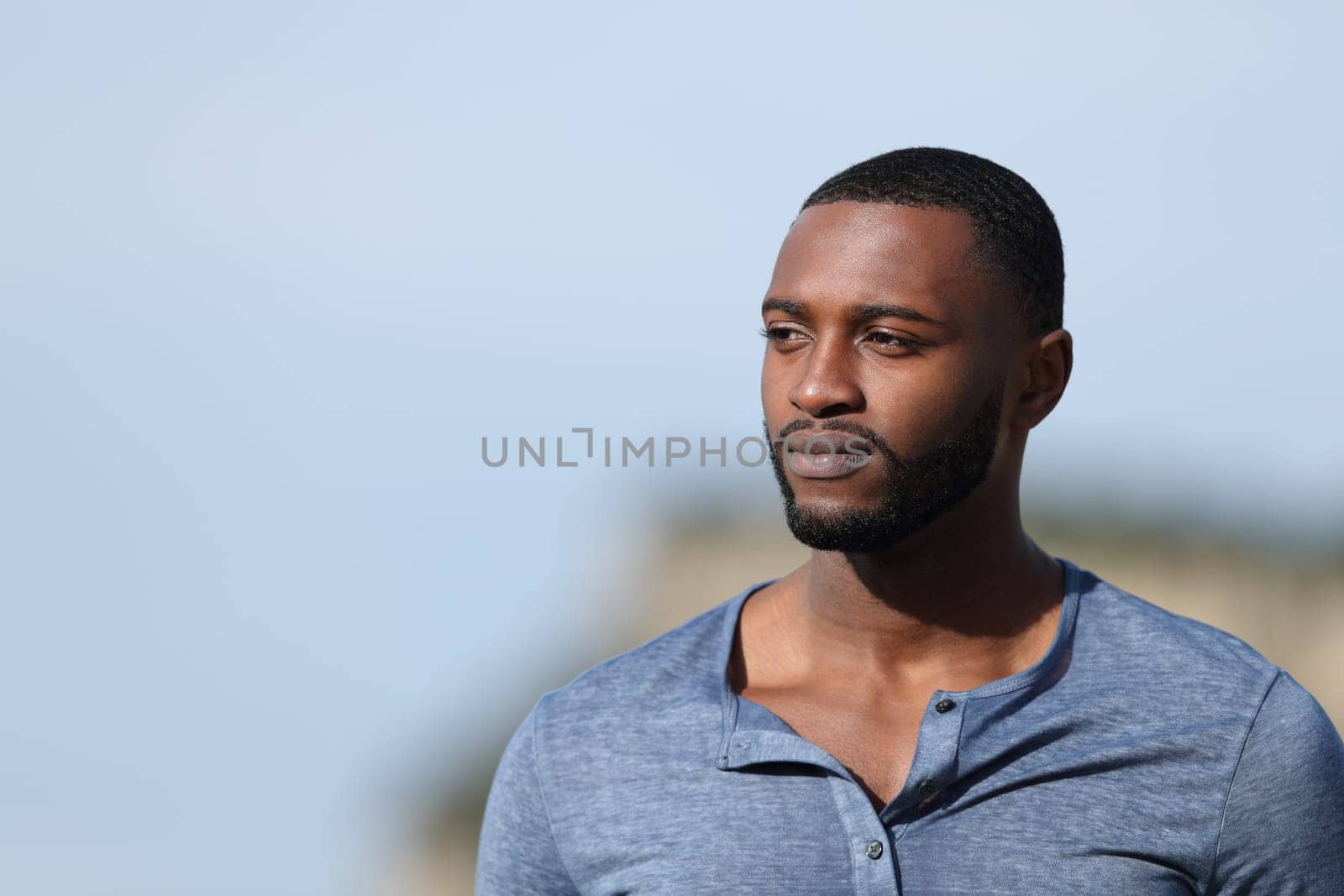 Serious man with black skin contemplating outdoors