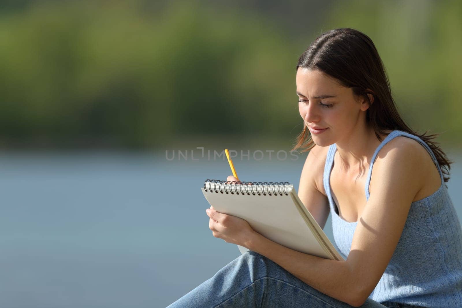 Woman drawing on notebook outdoors