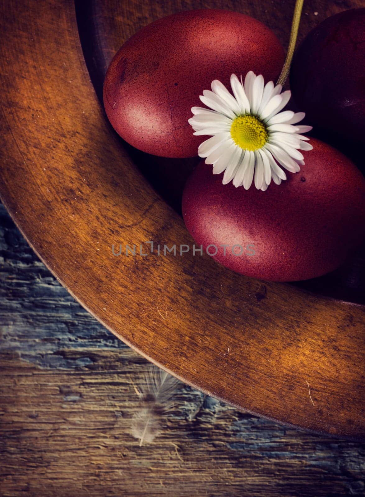 Red easter eggs in rustic wooden plate