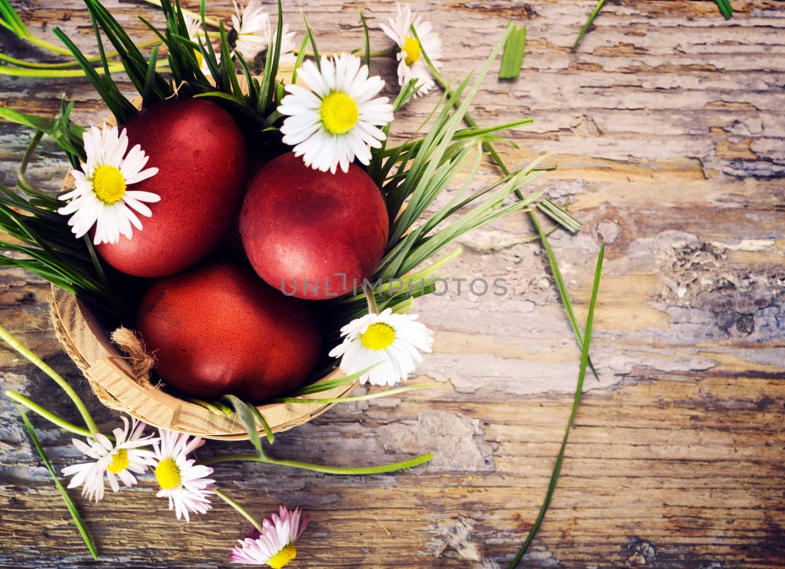 Red easter eggs in basket with flowers