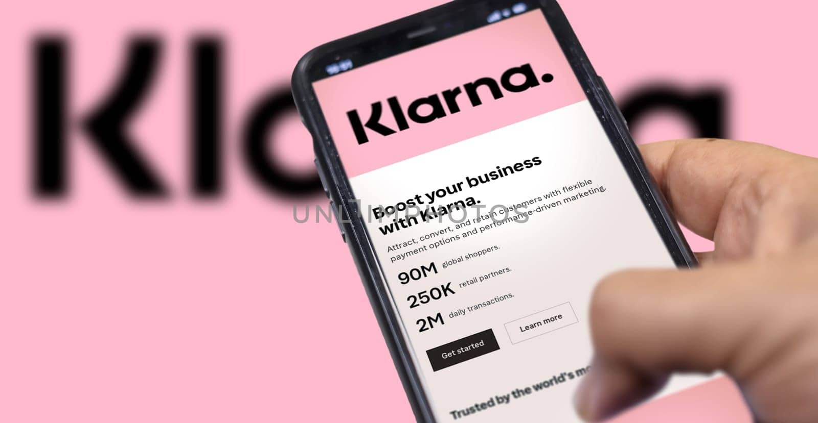 Rome, Italy, February 2022: Hand holding a device with the Klarna mobile app on the screen. Klarna is the largest private fin-tech start-up in Europe, founded by the bank of the same name. Illustrative editorial