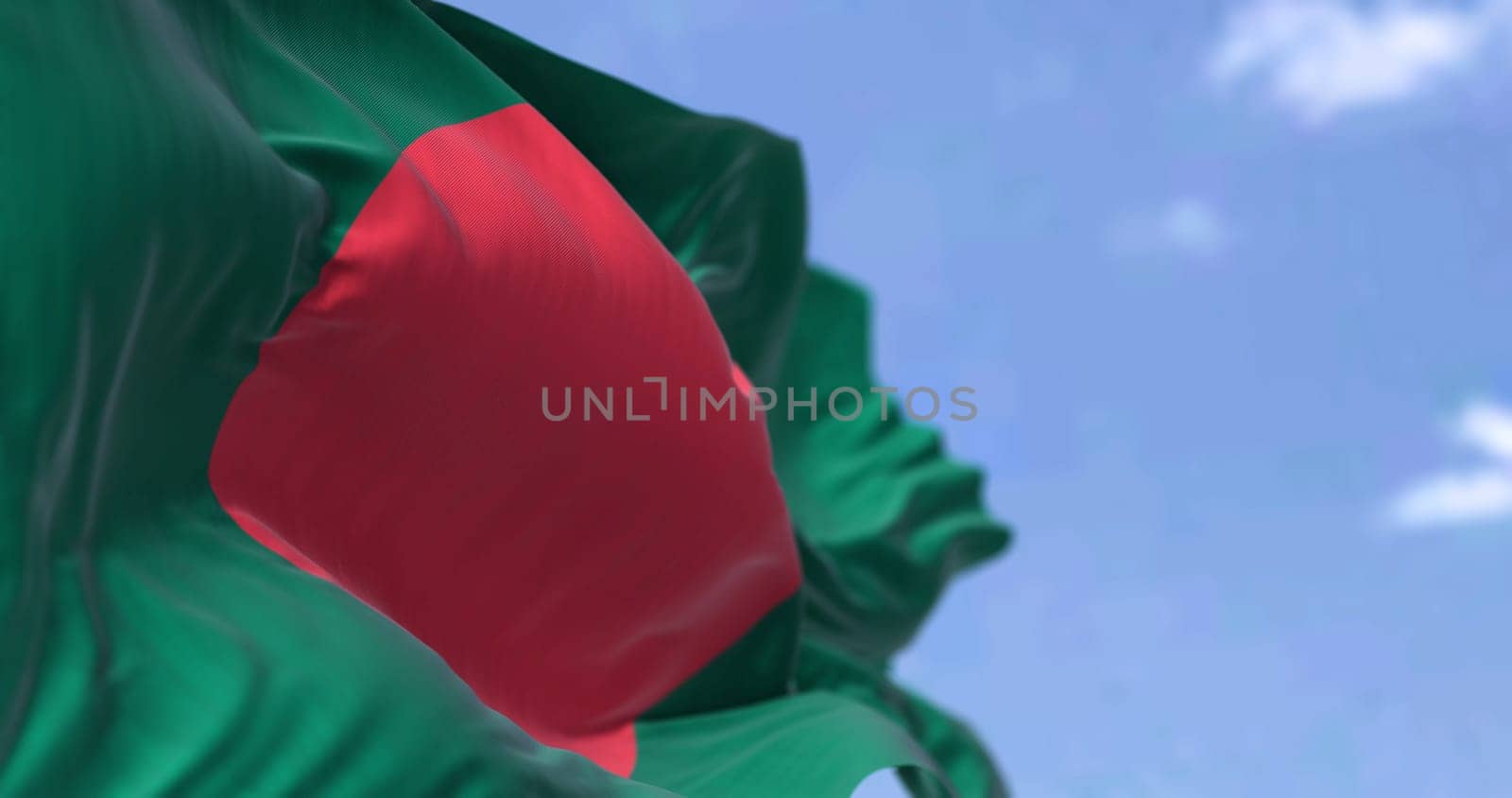 Detail of the national flag of Bangladesh waving in the wind on a clear day. is a country in South Asia. It is the eighth-most populous country in the world. Selective focus.
