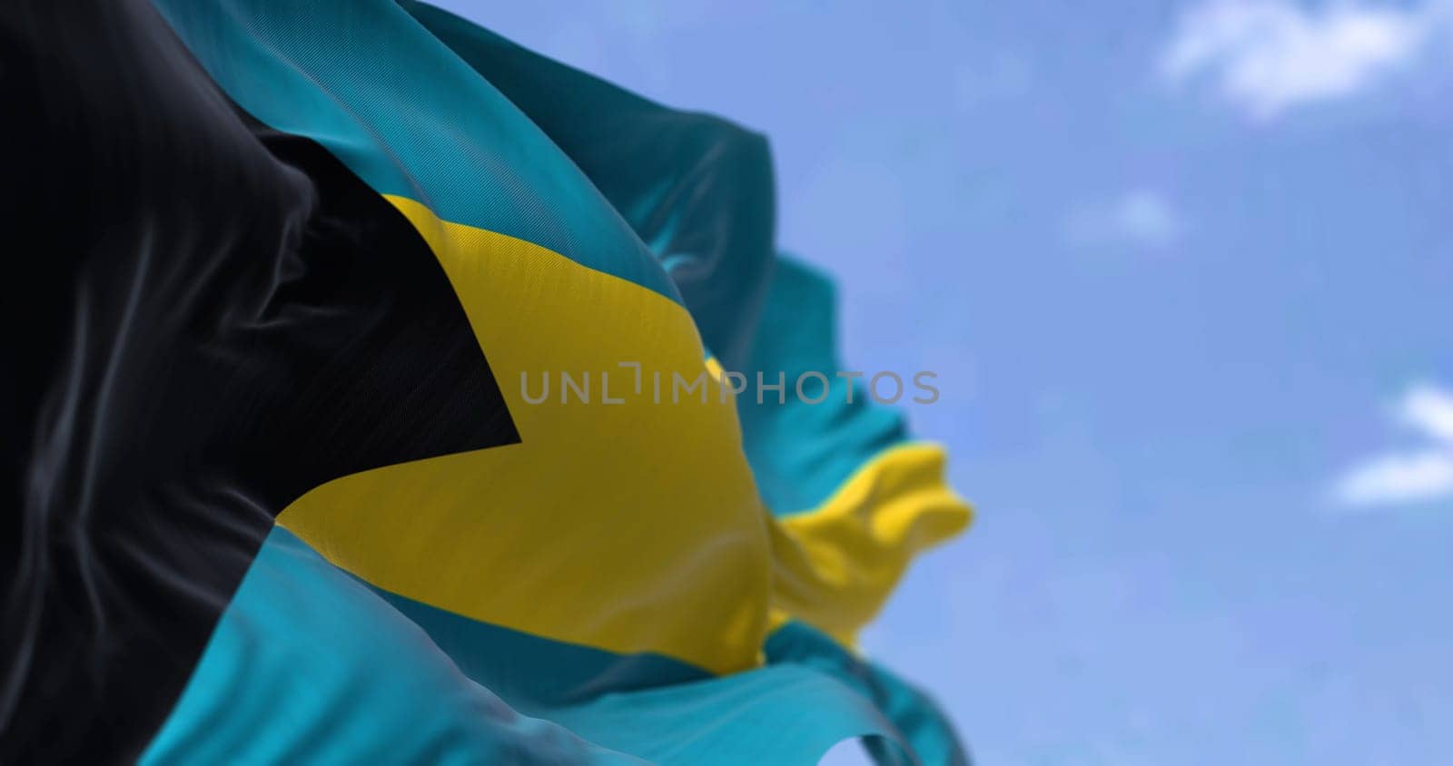 Detail of the national flag of the Bahamas waving in the wind on a clear day. Bahamas is a sovereign country within the Lucayan Archipelago of the West Indies in the Atlantic. Selective focus.