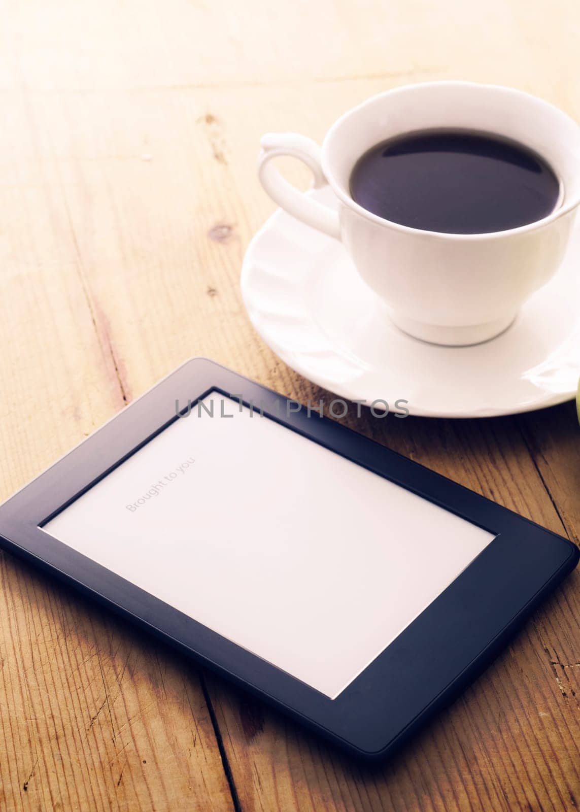 .E-book reader and coffee cup with morning light