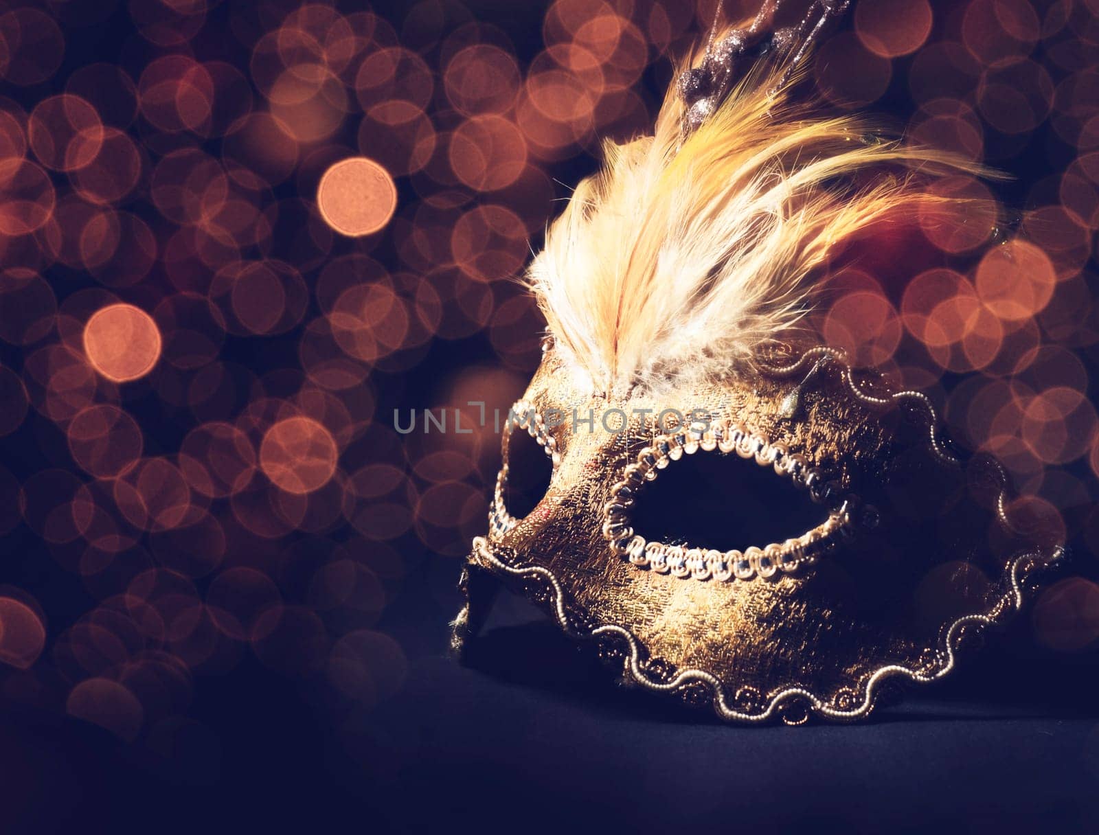 Golden venetian mask over black background