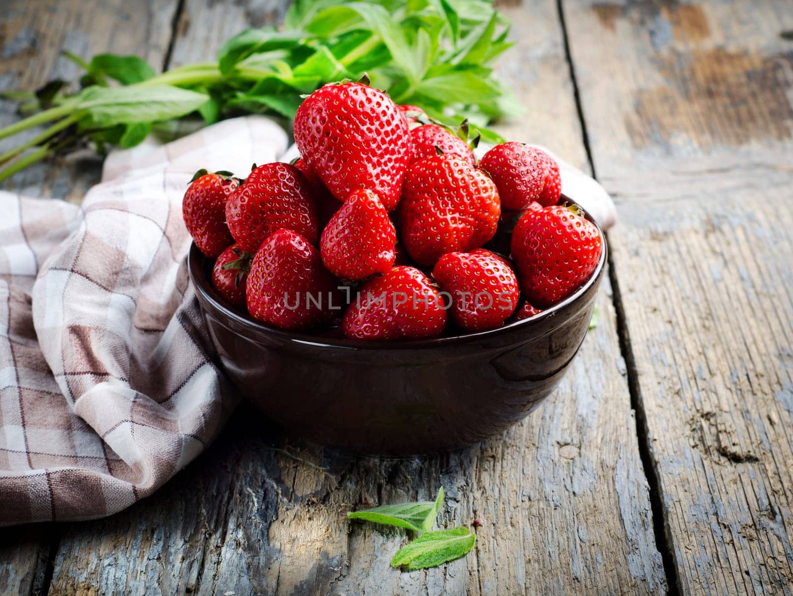 Strawberries in bowl on rustic table