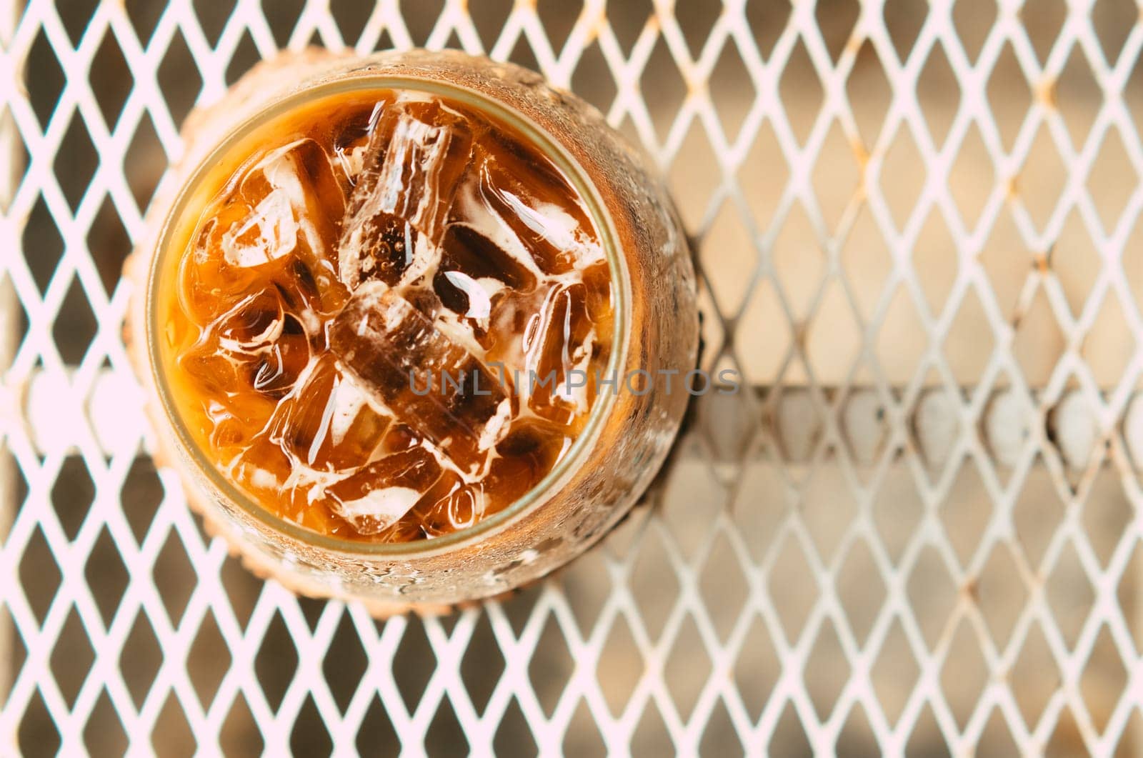 Iced latte coffee in a glass with cream on bottom . cold summer drink background