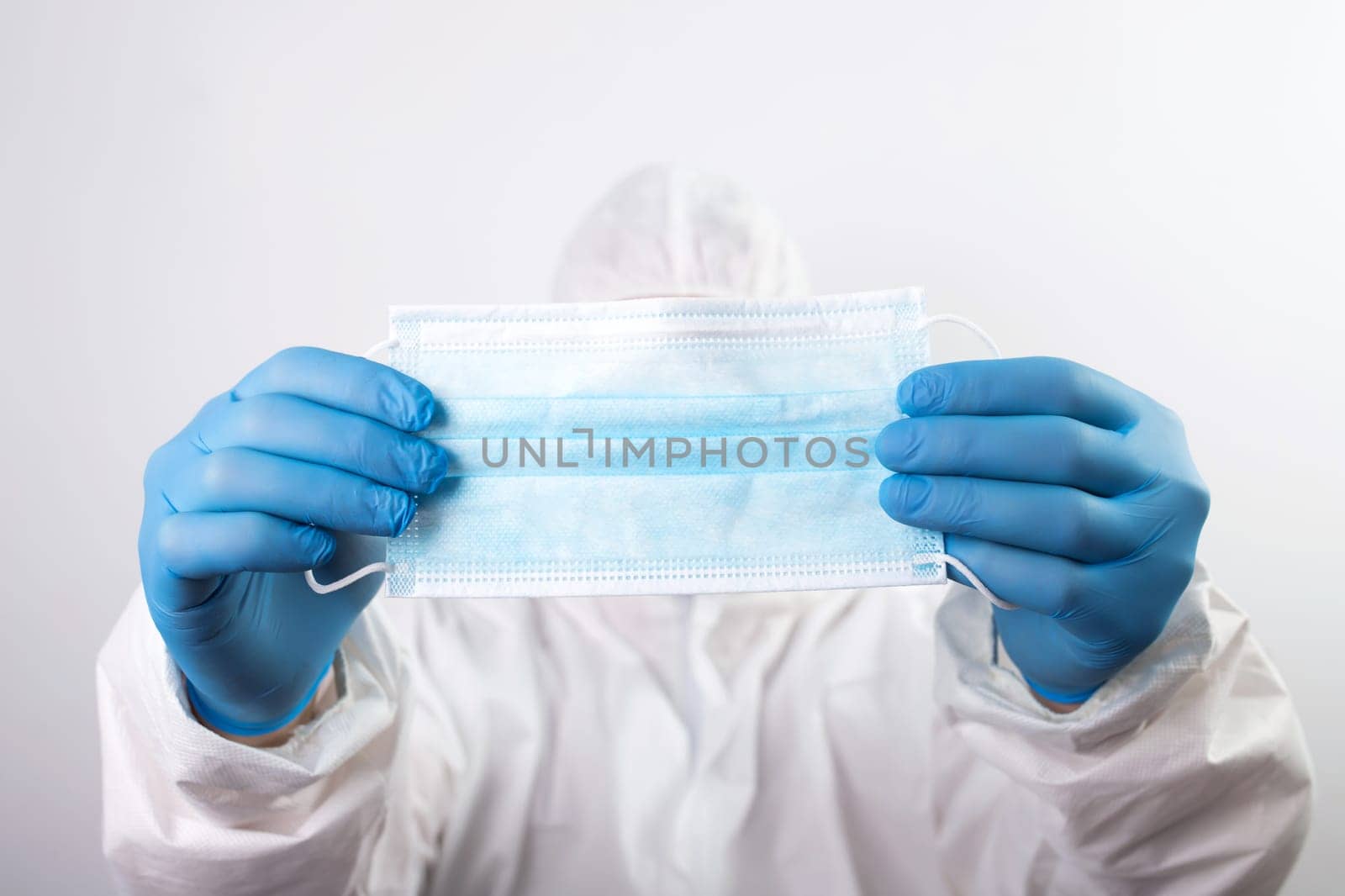 Doctor hand wear blue medical gloves holds antivirus face mask for pandemic diseases. Outbreak, Covid19 concept