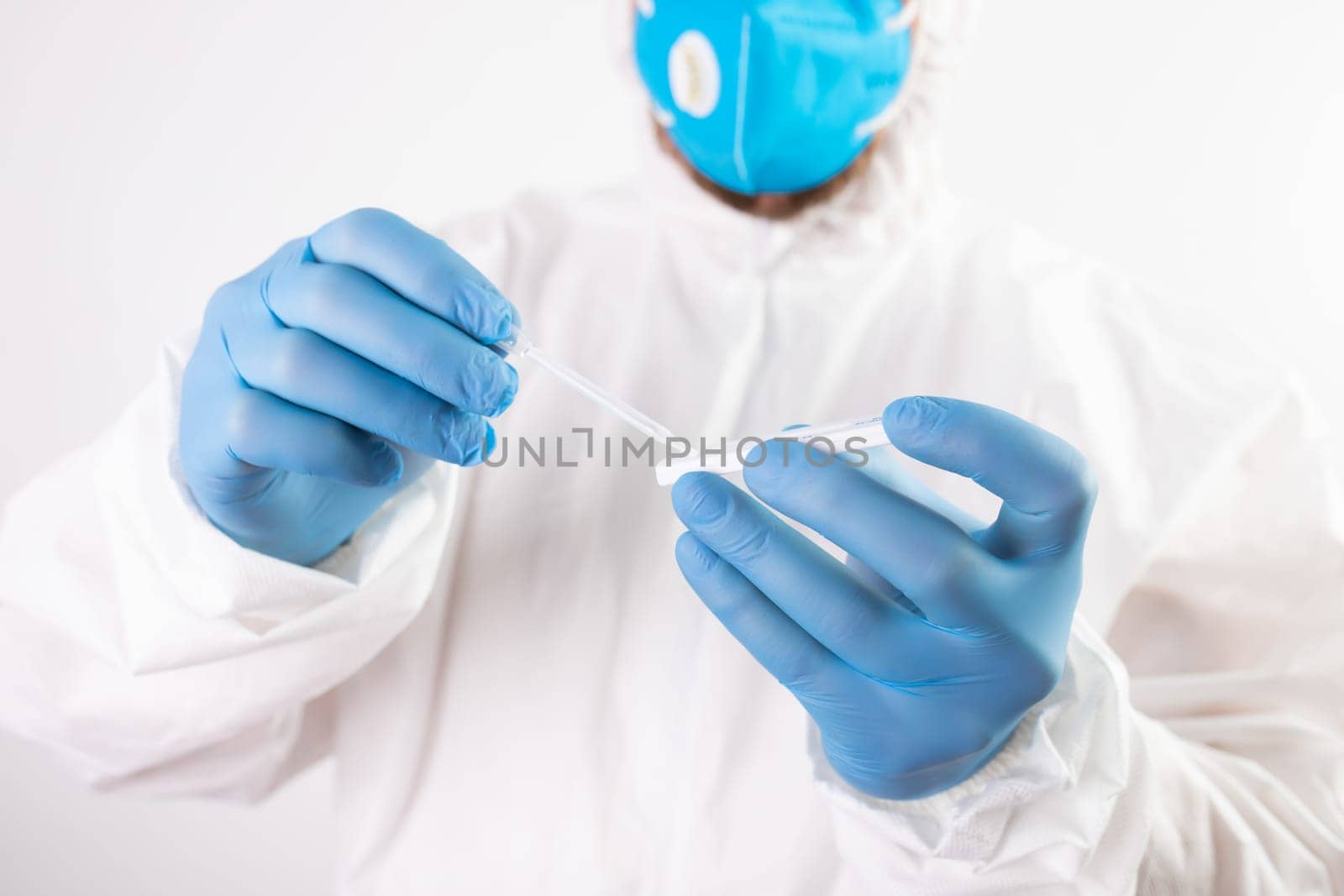 Medical healthcare holding COVID-19, coronavirus swab collection kit, wearing protective suit