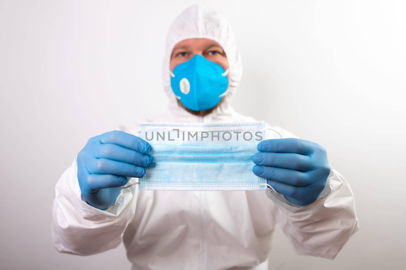 Doctor hand wear blue medical gloves holds antivirus face mask for pandemic diseases. Outbreak, Covid19 concept
