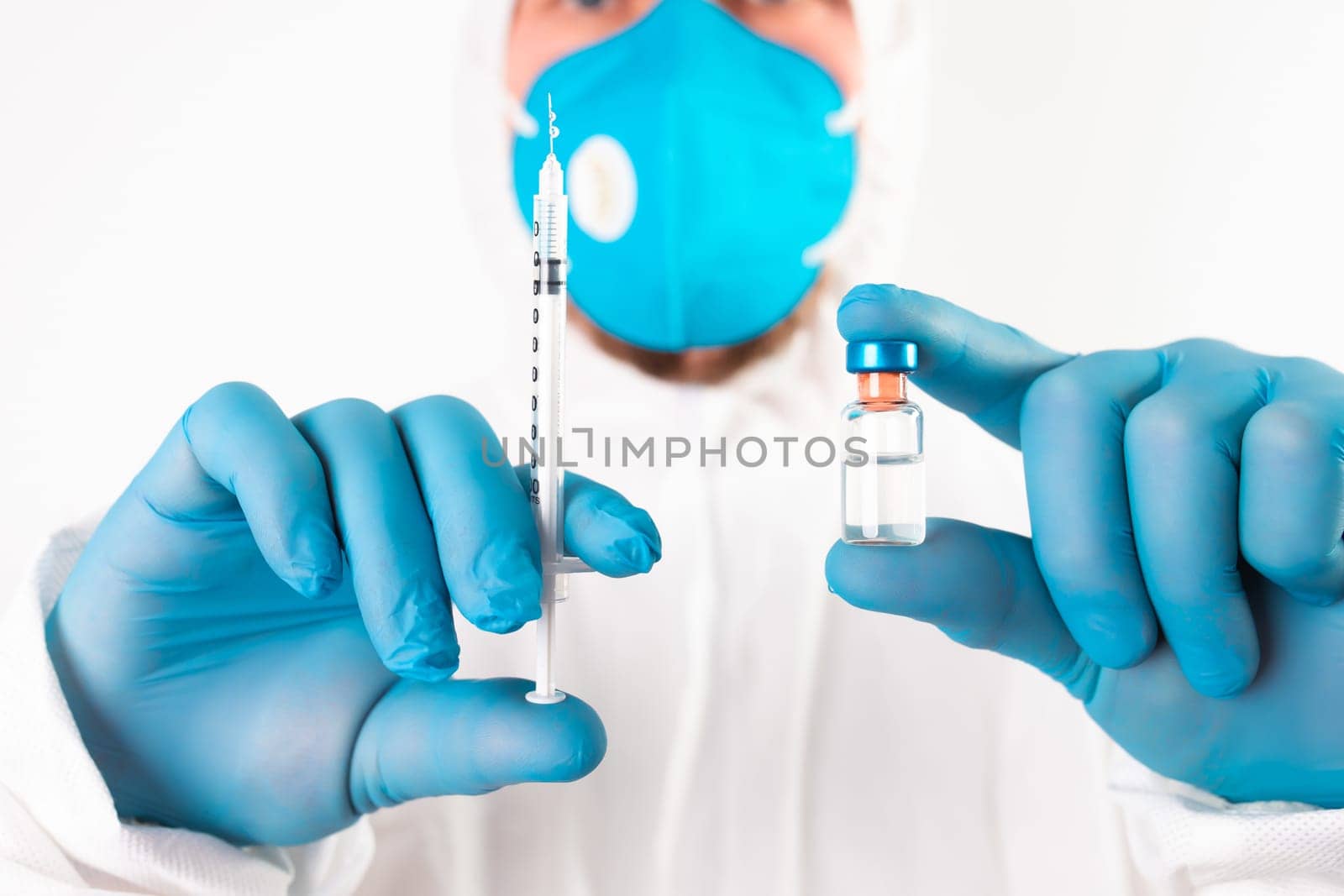 COVID-19 coronavirus vaccine. Vaccination concept. Doctor's hand in blue gloves hold medicine vaccine vial bottle and syringe.