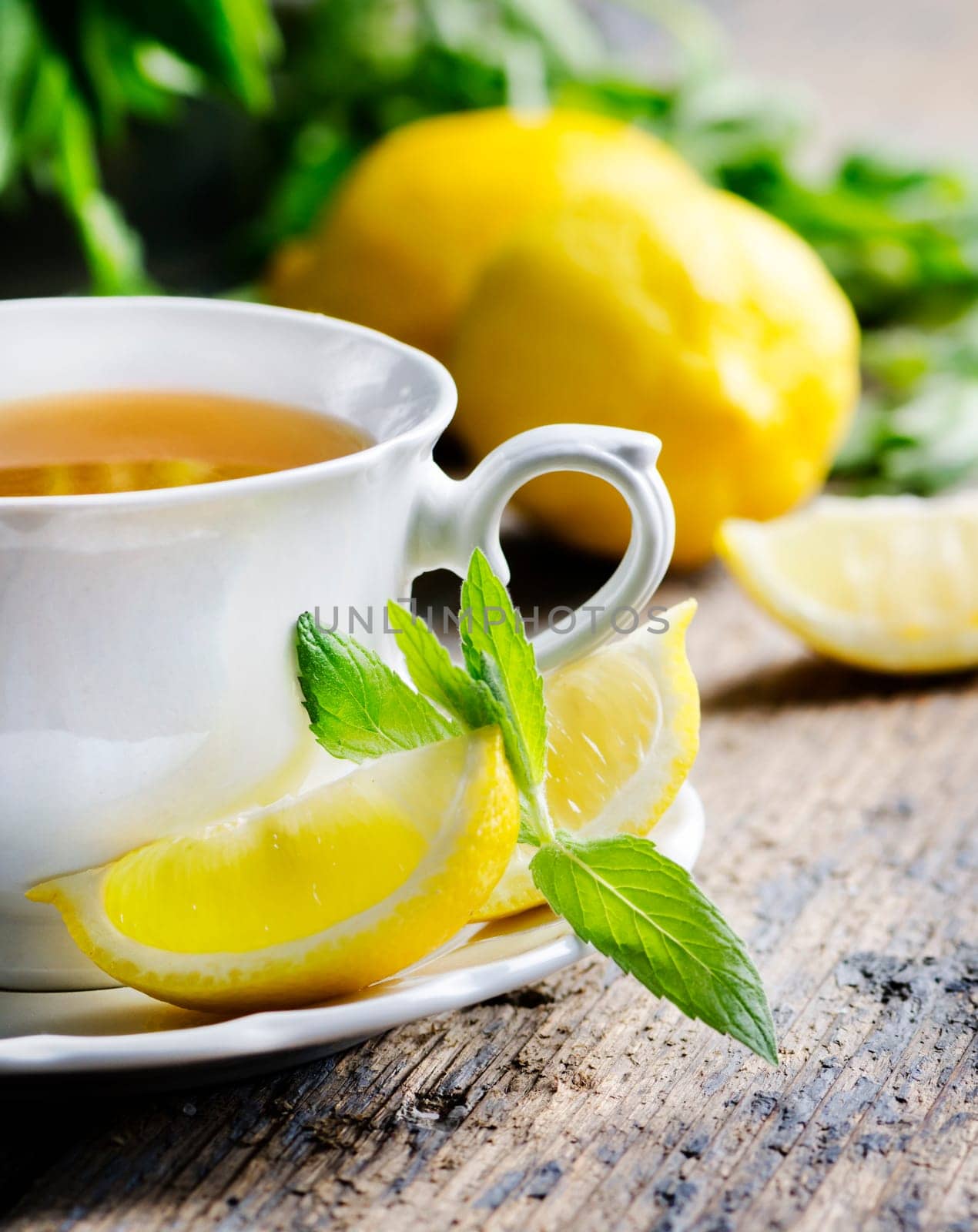 Cup of tea with mint and lemon slices.