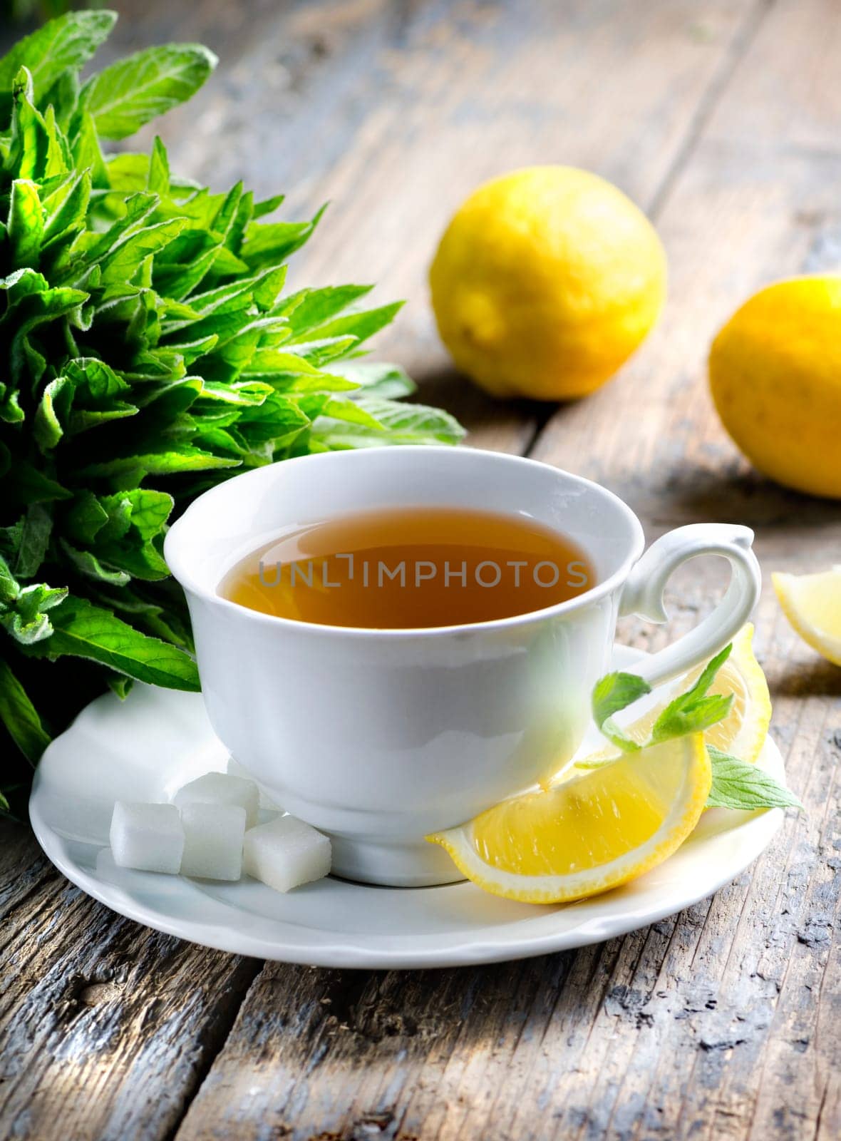Cup of tea with mint and lemon slices.