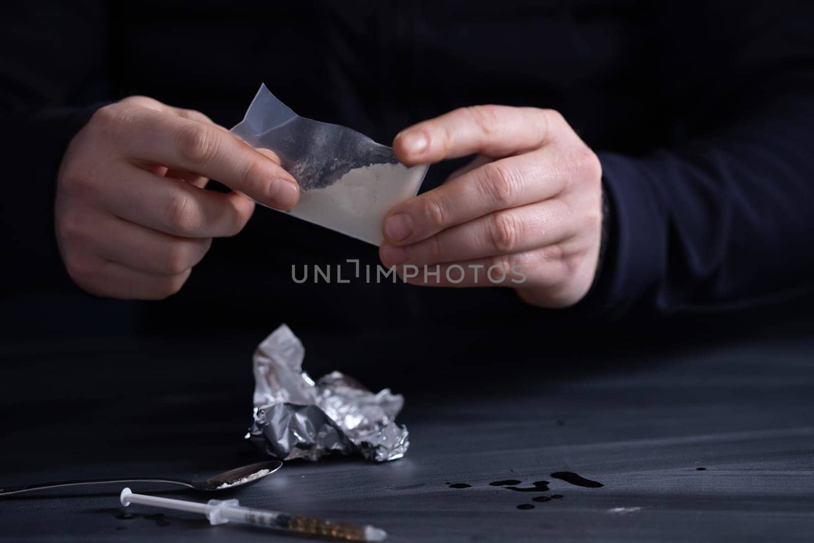 Addict/junkie man preparing drugs. The concept of crime and drug addiction.