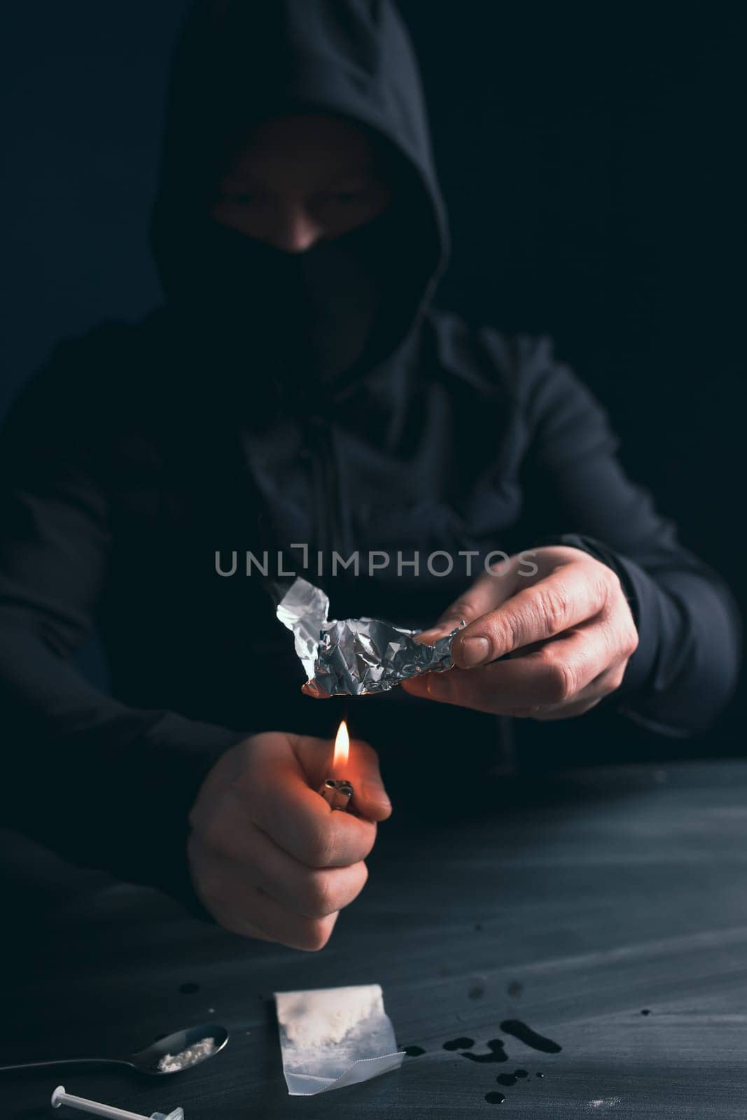 Addict/junkie man preparing drugs. The concept of crime and drug addiction.