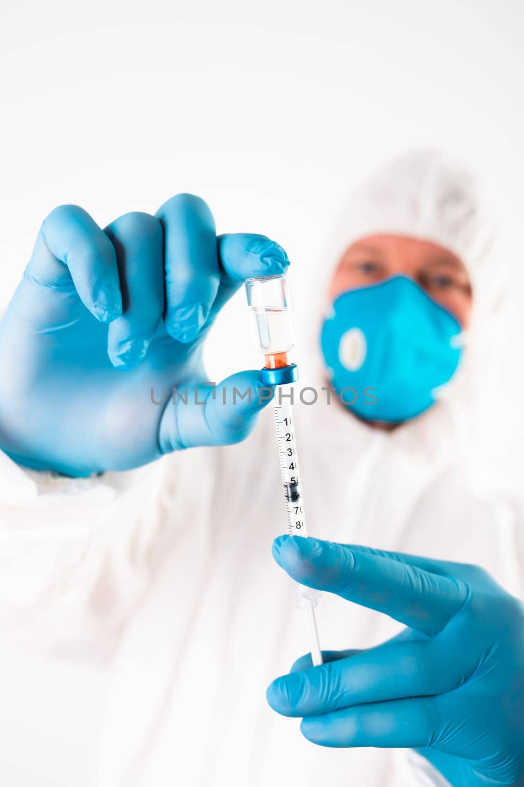 COVID-19 coronavirus vaccine. Vaccination concept. Doctor's hand in blue gloves hold medicine vaccine vial bottle and syringe.