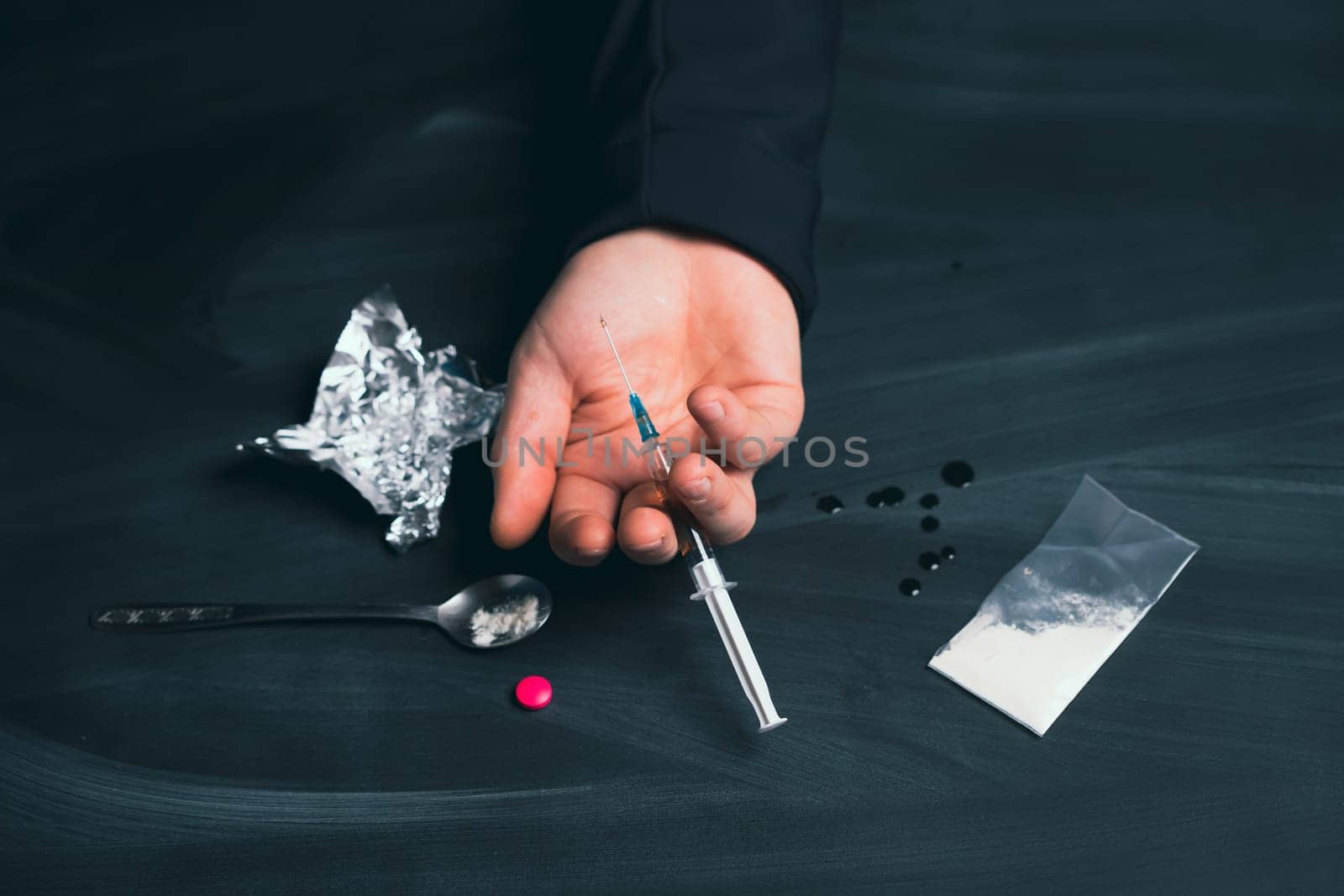 Drug addict reaches for another dose of drug. Concept of addiction, antidrug. International Day against Drug Abuse.